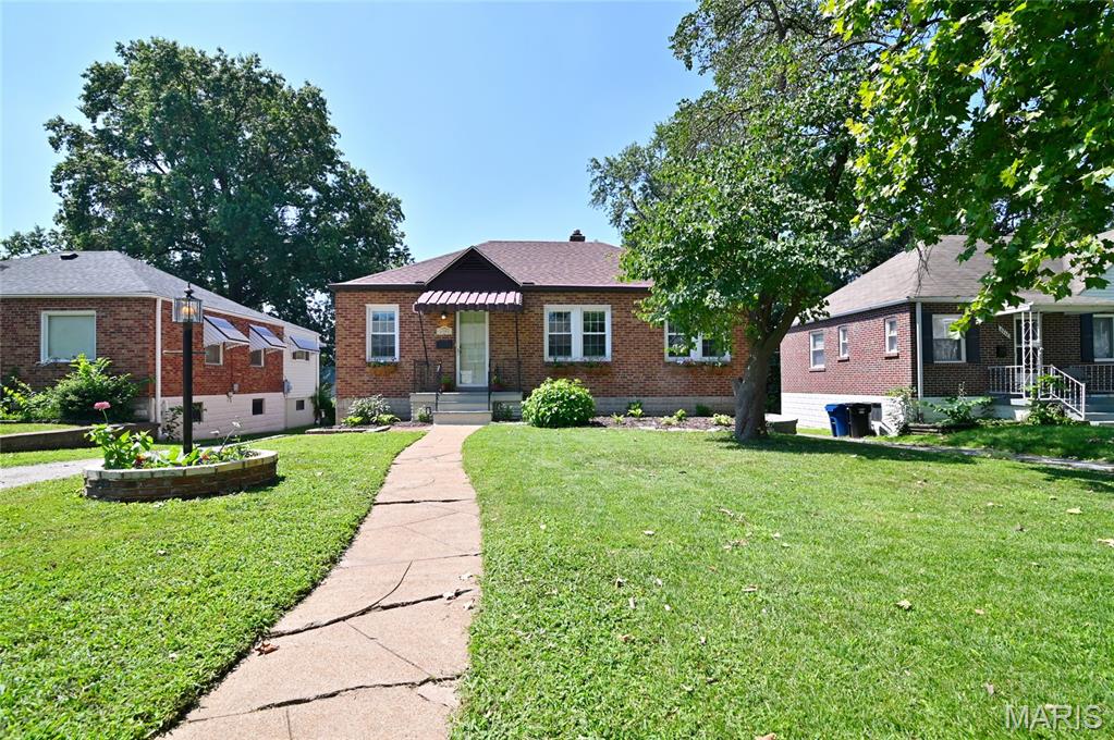 Looking for city charm in the county? You've found it! Full of charm and timeless character, this beautifully maintained brick bungalow in the sought-after Affton School District offers the perfect blend of classic craftsmanship and modern updates. Built in 1940, this home is anything but cookie cutter! Step inside to a cozy living room wrapped in windows (plus a skylight!) that floods the space with natural light. Arched doorways, high ceilings, hardwood floors, and wide trim are just a few of the details that make this home so special. They simply don't build them like this anymore! The formal dining room is ready to host your next gathering, while the beautifully updated kitchen steals the show with stylish cabinetry, updated countertops, floating shelves, a classic white tile backsplash, a bold navy accent wall, updated flooring, and a spacious pantry. The refrigerator, washer, and dryer are all included, making your move even easier. Need more space? The finished lower level offers endless possibilities with additional living space, recessed lighting, cool tile flooring, a full bathroom, and abundant built-in storage in both the laundry room and garage, perfect for guests, a home office, workout room, or movie nights. Step outside to your private backyard featuring a beautiful patio that's perfect for morning coffee, outdoor dining, or evenings gathered around a fire pit. The wraparound driveway leads to a convenient tuck-under garage, offering plenty of parking and storage. Major updates including a new roof and new water heater provide added peace of mind. Ideally located next to Grant's Farm and the 9 mile garden, as well as within walking distance of local restaurants, you'll enjoy the charm of a quiet, welcoming neighborhood with easy access to parks, shopping, and major highways. If you've been searching for a home with personality, modern conveniences, and an unbeatable location, this one checks all the boxes. Come see why this timeless bungalow is ready to welcome you home!