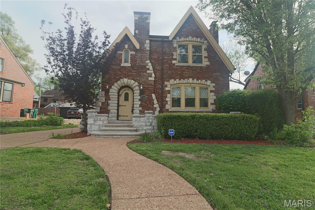 NATIONAL REGISTER OF HISTORIC PLACES....Historic home in the St. Louis suburb of Pasadena Hills. This Classic English Tudor Revival Features elaborately detailed Multi-colored brick with infused ashlar limestone rock. The castle-like entrance features a large tile open porch and limestone arch with wood plank door and vintage hardware. The roof line is steeply pitched with intersecting cross gables that merge into a large chimney with a shed roof behind it. There are some arched windows, some with stained glass, and arched interior doorways. Enter the foyer to this inviting home.  Feel the allure that draws you into the formal area, beaming floors lead you to the formal dining area. Complete with Large Picturesque window in Living Rm and Dining Area. Continue on into the sitting area which provides for extra comfort  on the main level. Kitchen features light ash cabinetry ,tiled countertops, ceiling fan, natural lighting,...Kitchen leads to nice deck and  patio.  Two Car Detached Garage.   Upper level graciously offers 3 roomy bedrooms.  All with ceiling fans and ample closets.  Second bedroom leads to second level deck., with beautiful overlook of the groomed back yard. Master bedroom is expansive , featuring walk-n closets, en suite washer/dryer hook up. Updated Full master bath with massive shower !  Basement is freshly painted and clean.  New hardware on doors.  Tree lined streets create a walking community to nearby fountain and pond.  Minutes  drive away from University of Missouri!