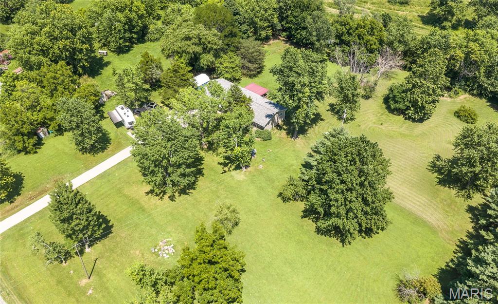 Discover the perfect blend of peaceful country living and modern comfort in this beautifully maintained 3-bedroom, 2-bath home nestled on 2.5 picturesque acres. Surrounded by mature apple and peach trees, this property offers a private retreat where you can enjoy the beauty of every season while still having all the conveniences of home. Step inside to an inviting open floor plan designed for everyday living and effortless entertaining. The spacious kitchen is the heart of the home, featuring a large island with a breakfast bar, stainless steel appliances, and plenty of room to gather with family and friends. The washer, dryer, and even the living room TV will stay with the home, making your move even easier. One of the home's most memorable features is the stunning fireplace, accented with authentic arrowheads that add a unique touch of character you won't find anywhere else. Outside, you'll love spending evenings on the huge covered back deck overlooking the fenced backyard, perfect for pets, play, or simply relaxing in the fresh air. Two storage sheds, a chicken coop, and ample outdoor space offer endless possibilities for gardening, hobbies, or creating your own mini homestead. Major updates, including a new roof in 2019 and a freshly paved driveway in 2024, provide added peace of mind. If you've been searching for a home that combines charm, acreage, and thoughtful updates, this one is a must-see. Schedule your private showing today and experience everything this exceptional property has to offer!
