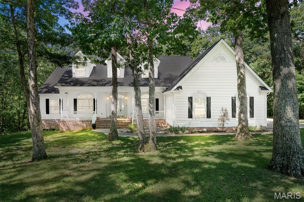 Tucked away at the end of a cul-de-sac on almost 6 private wooded acres, this stunning custom ranch offers the perfect blend of luxury and tranquility. A charming brick front porch welcomes you to the comfort and serenity of the surroundings. Take a seat and savor the natural beauty and peaceful setting that make this property so special.

Step through the foyer and admire the gleaming hardwood floors that lead into a dramatic vaulted great room featuring floor-to-ceiling windows showcasing breathtaking wooded views. The great room is complemented by a spacious dining area and flows seamlessly into the kitchen and breakfast room, creating an ideal space for entertaining. The gathering space extends outdoors through French doors that open to a covered, stamped concrete wraparound deck—perfect for relaxing or hosting guests while surrounded by nature.

Just off the foyer, a spacious den with beautiful custom wood built-ins provides the perfect home office or reading retreat. The primary suite overlooks the private wooded setting, while a second bedroom and full bath offer comfort and convenience for family or guests. The main level also features a large pantry, powder room, and oversized laundry area.

The oversized side-entry 3-car garage offers abundant space for vehicles, recreational equipment, tools, and hobbies. The walkout lower level, complete with multiple windows, is ready for your vision and provides excellent potential for additional living space.

Located in the sought-after Ellerman Oaks subdivision and within the North Point High School boundaries, this exceptional property offers privacy, quality craftsmanship, and room to grow—all in one remarkable home.