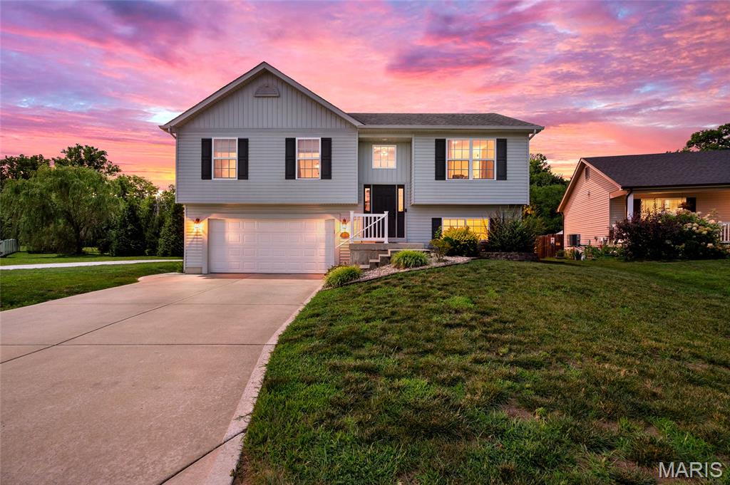 Welcome home to this adorable, budget-friendly gem in the charming Anna Meadows neighborhood! Built in 2014, this move-in ready home offers 3 bedrooms, 2.5 bathrooms, and a functional layout that's perfect for everyday living. The bright kitchen features beautiful wood-tone cabinetry, granite countertops, stainless steel appliances, and a spacious dining area for gathering with family and friends. Just off the kitchen, the inviting living room is highlighted by a stunning black shiplap electric fireplace that adds the perfect modern touch. The primary suite includes a private ensuite bathroom with an oversized shower, while two additional bedrooms share a full bathroom with a tub/shower combination. Downstairs, you'll love the finished lower level offering a second living space or rec room, plus a convenient half bath, laundry area, and plenty of storage. Outside, the oversized two-car tuck-under garage provides extra room for vehicles and storage, while the huge backyard backs to trees, offering privacy and endless potential for a future deck, fence, or outdoor entertaining space. Located with quick access to Highway 40/64, this home combines small-town charm with an easy commute. If you've been searching for an affordable home that checks all the boxes, this is one you won't want to miss!
