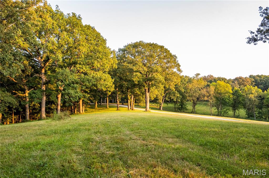 Experience the perfect combination of natural beauty and modern convenience on this stunning 22+/- acre property featuring underground utilities, including electric and county water. Surrounded by mature hardwood trees and offering breathtaking lake views, this serene setting provides outstanding sites to build your dream home, shouse, or barndominium. The land is teeming with exceptional wildlife, including turkey & monster bucks, creating a peaceful retreat for nature lovers and outdoor enthusiasts alike. Protective deed restrictions ensure lasting beauty and privacy: up to two homes (minimum 1,200 sq. ft.) no subdividing, no mobile or modular homes, no hog confinement buildings, no junkyards, no race tracks, no VRBO/Airbnb use, and no logging with the exception of building purposes or dead tree removal. With additional acreage available, this rare opportunity offers the perfect backdrop for your custom country home or recreational getaway. Deer photos are from the parent 435+/- acre tract and may or may not have been taken on this parcel.  Agent owned.