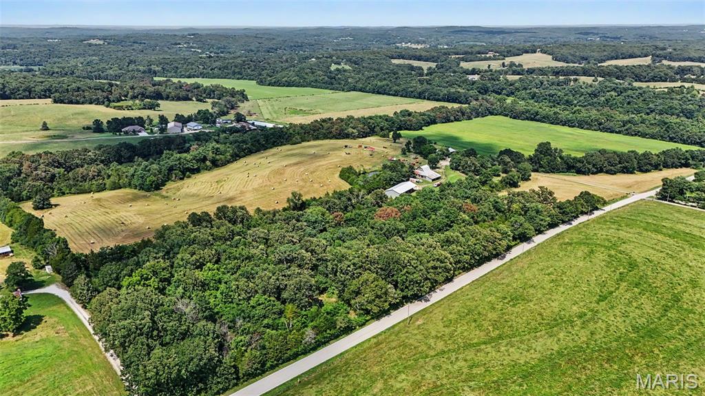 If you've been searching for a real farm with a cozy farmhouse and plenty of room to work the land, this is it. Situated on approximately 78 acres, this property offers the privacy, functionality, and country charm that are becoming increasingly difficult to find.

The 2,229 square foot home features 4 bedrooms, 2.5 bathrooms, beautiful hardwood floors, a charming country kitchen, expansive living room windows overlooking the property, and a walkout basement with a cozy wood burning stove. A covered wrap around porch provides the perfect place to enjoy the peaceful surroundings and scenic countryside.

Currently used for hay production and crops, the land is well suited for cattle, horses, hobby farming, or those looking to embrace the homesteading lifestyle. Some perimeter fencing and fencing around the front pasture are already established. Enjoy a stocked pond with largemouth bass and bluegill, creek access, open pasture, and productive acreage that offers both recreation and agricultural opportunities.

The property's outbuildings provide the infrastructure needed for country living, including a historic barn full of country charm and potential, machine storage, workshop space, covered equipment storage, and dedicated hay storage.

Whether you're looking to continue its agricultural use, start a homestead, or simply enjoy the peace and beauty of country living, this property offers the space, functionality, and character to make it your own.
Showings start Saturday 7/11 at 9am.