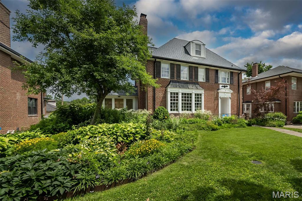 Stately, full of character and comfort, this classic three-story home sits in the heart of Clayton’s highly sought-after Hillcrest neighborhood—known for its charm, walkability, and tree-lined streets. A gracious foyer welcomes you into spacious, light-filled rooms featuring hardwood floors, oversized windows, and timeless architectural details. The formal living and dining rooms offer wonderful flexibility for everyday living and entertaining.
A remarkable 1400 sf 2008 addition creates a bright, open, kitchen and family room with vaulted ceilings, skylights, and abundant gathering space. The white kitchen offers extensive cabinetry, a center island, dual ovens, upscale induction cooktop, and ideal flow into the adjoining family room,  sunroom & composite deck—perfect for relaxing or enjoying the outdoors in every season. The spacious main-floor primary suite is a rare luxury in Clayton and a true highlight of this home. Bright and airy with multiple windows and vaulted ceilings. A generous walk-in closet provides exceptional storage and organization. The adjoining primary bath features an extended double vanity, dedicated makeup area, walk-in shower, and a deep soaking tub. Thoughtfully positioned for comfort and convenience, this main-level suite enhances long-term livability or flexible space for multiple generations, and sets this home apart in the Hillcrest neighborhood.
 The second and third floors provide generous bedroom space, additional baths, and options for offices, playrooms, or private retreats. 
Newer HVAC, dedicated 240V circuit for EV charging, sprinkler system, new steel roof, west flat roof and skylights '26.  12kW Solar panels offer amazing utility savings! Space for a main floor laundry on main level.  FPL is as is.  Unbeatable proximity Forest Park, Captain Elementary, restaurants, and both Clayton and CWE vibrant amenities, this home presents an exceptional opportunity in one of the area’s most desirable neighborhoods. Don’t miss this rare opportunity to own a beautifully updated home in one of the area’s most walkable and desirable locations—now at an exceptional new price!
