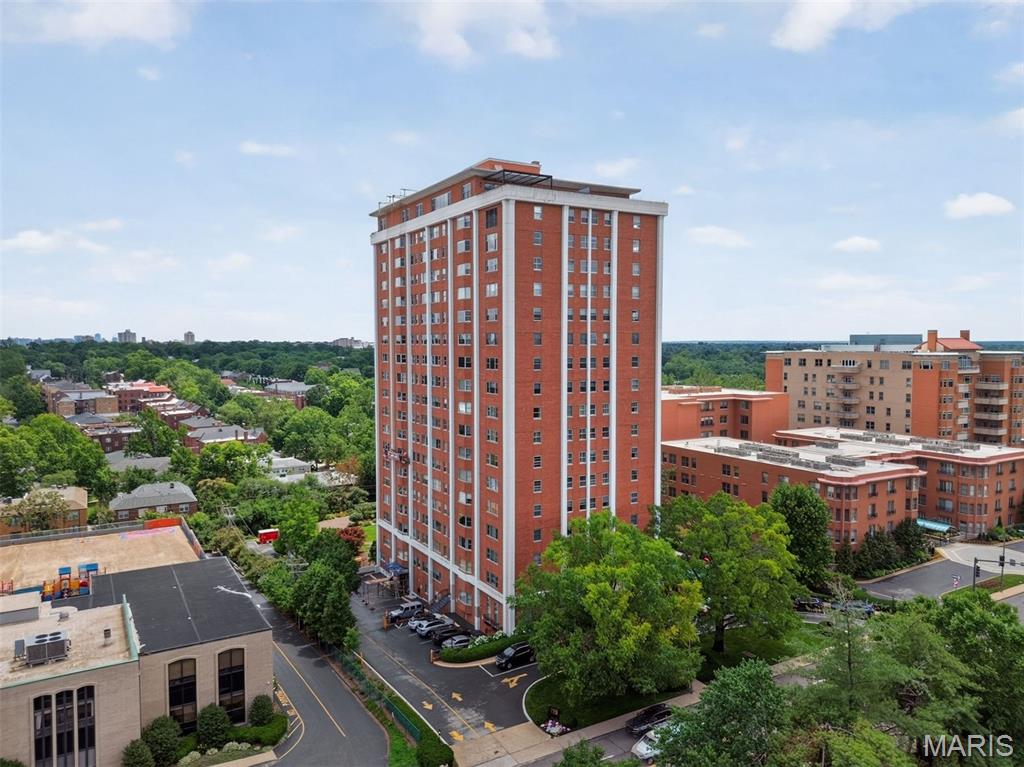 Welcome to the beautiful Whitehall Condominiums in Clayton! Perched on the 10th floor, this stunning residence offers sweeping views of Clayton and the surrounding areas from three exposures, paired with an exceptional blend of comfort, character, and convenience. Step inside to a welcoming foyer with parquet floors that continue throughout much of the home. The brand new kitchen features gray shaker cabinetry, stainless-steel appliances, and timeless finishes. The spacious living room is highlighted by a striking floor-to-ceiling mantel with an electric fireplace insert, creating a warm, inviting focal point. Adjacent to the living room, the formal dining room showcases breathtaking views through a charming bay window. The inviting den offers rich wood paneling, elegant wainscoting, and wall-to-wall built-in bookcases, providing the perfect space to relax or entertain. Three generously sized bedrooms and three full bathrooms offer plenty of room for family, guests, or a home office. An added bonus is an in-unit washer/dryer and two designated garage parking spaces. Residents of Whitehall enjoy an unmatched lifestyle with exceptional amenities, including a 24-hour doorman, outdoor pool, fitness center, library, beautifully maintained gardens and patios, dog run, and spacious community gathering areas. Experience luxury high-rise living in one of Clayton's most desirable communities.