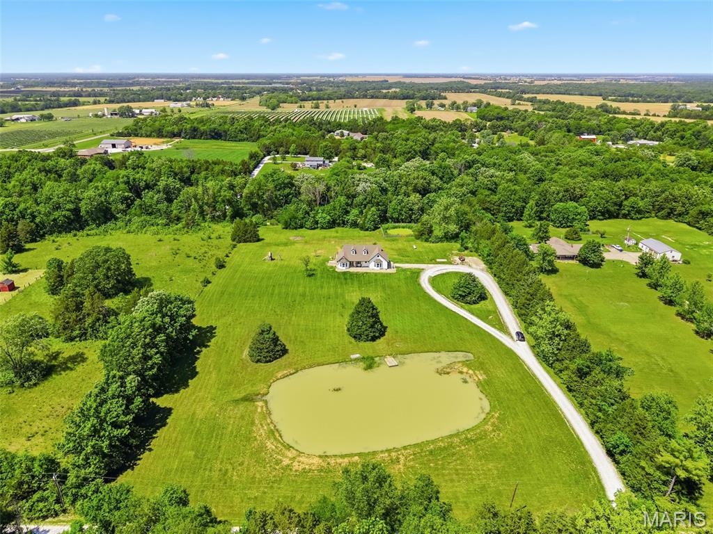 This RARE FIND offers the freedom of NO HOA, making it a true gem in today's market! Experience peaceful country living in this custom-built walkout ranch, situated on 5 acres with ample space for your large garden and animals. Imagine fishing from your own stocked pond, relaxing in the expansive open yard, and enjoying privacy thanks to the mature trees that line the property. -- You'll love the modern farmhouse color scheme on the exterior and several recent updates including new LVP flooring on the main floor, new siding, gutters, soffit, fascia, some fresh paint, and a new exterior back door—all completed in 2026. The home also features a new roof installed in 2023. Step out onto the new deck (2026) for stargazing or unwind in the spacious great room with windows overlooking the nature views. -- The main floor also includes, a country kitchen, a dining area, a laundry room, a primary bedroom suite with a soaking tub, separate shower, and a large walk-in closet. There are two additional nicely sized bedrooms and a hall bath. The walkout lower level features a spacious bedroom or recreation room, a rough-in bath, and ample space for storage & future finishing options. An underground pet fence is also included. -- This property comes with a private shared road agreement and a $250 annual fee for gravel and road maintenance (but not in an HOA). Don't miss your chance to own this one-of-a-kind property—schedule your tour today!