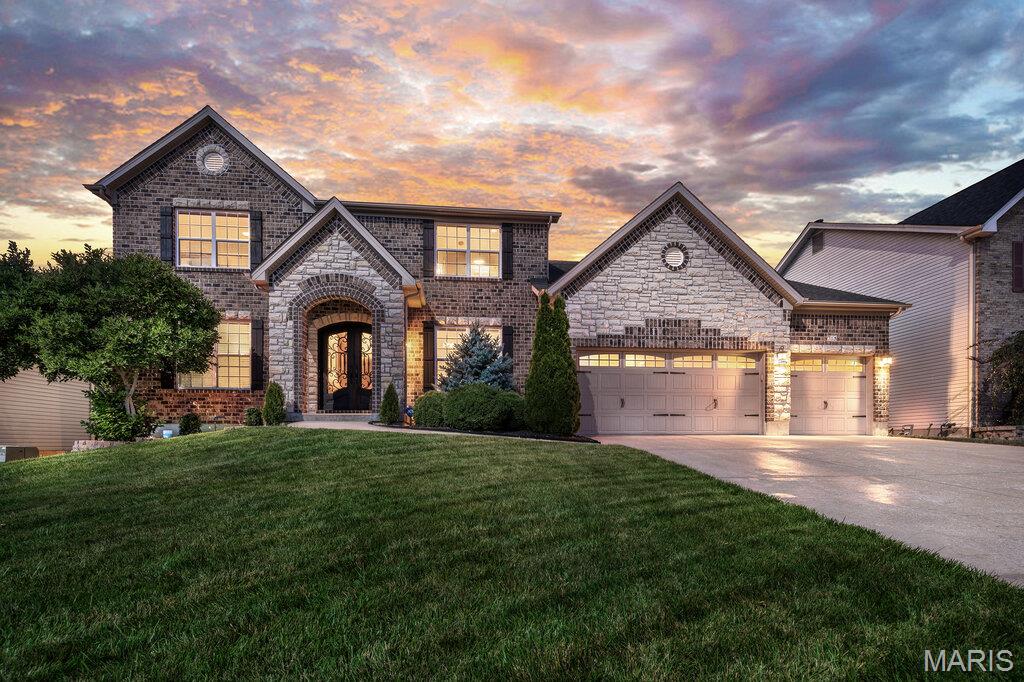 Welcome to this stunning 1.5 story home in the highly sought after Manors at Fieldstone Farms! Offering more than 3600 sq feet of beautifully designed living space, this exceptional 5-bedroom, 3.5 bath home is ideal for growing families and those who love to entertain. From the striking stone and brick exterior to the gorgeous custom front doors, this home makes a lasting first impression. Step inside to find rich hardwood flooring throughout the main level, complemented by elegant travertine and ceramic tile, crown molding and a handcrafted staircase with iron balusters. The spacious gourmet kitchen features stainless steel appliances, gas range, solid surface countertops, stylish backsplash and plenty of space for gathering with family and friends. The main floor primary suite with bay window offers a private luxury bath with soaking tub, separate shower and double bowl vanity. Upstairs, you will find four generously sized bedrooms, including one with a private en-suite bath, while two additional bedrooms are connected by a convenient Jack-and-Jill bathroom. A large bonus room provides the perfect space for a media room, playroom, home office, fitness area or additional living space to suit your needs. Additional features include an oversized 3-car garage, a 9-foot basement pour offering endless opportunities for future finishing, zoned HVAC system, large exterior deck, irrigation system, fenced yard & community pool. Conveniently located near highway 40/61, plenty of restaurants & shopping this wonderful home is sure to go quickly!