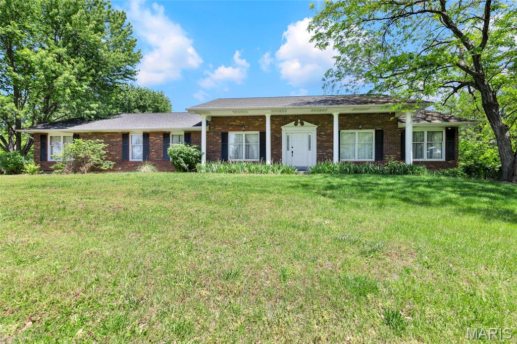 Step back into a different era with this charming all-brick ranch in unincorporated St. Charles County — a home full of timeless character, mature landscaping, and a setting that’s increasingly hard to find. Situated on 3.08 acres surrounded by towering trees and set back by a long private driveway, this 4-bedroom, 3-bath property offers privacy, space, and vintage charm in a truly park-like setting.

The full-width covered front porch with classic white columns creates inviting curb appeal, while inside you’ll find a spacious and functional layout featuring a large living room, formal dining room, and a cozy family room with a brick fireplace and French doors overlooking the backyard green space.

The kitchen offers abundant cabinet space and easy flow into the main living areas. The primary suite includes double closets and a private ensuite bath, while three additional bedrooms provide flexibility for guests, hobbies, or a home office.

What truly makes this property special is the land — open, level, and lined with mature hardwood trees that create a peaceful atmosphere rarely found today. This is a rare opportunity to own a well-built home with incredible character and endless potential to make it your own.

Schedule your showing today.
