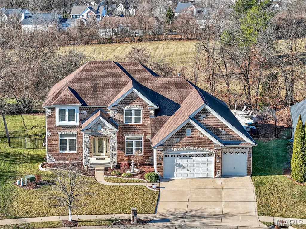 Designed for both everyday comfort and unforgettable entertaining, this exceptional 1.5-story home offers nearly 5,500 sq ft of beautifully finished living space with impressive craftsmanship throughout. Rich Brazilian Cherry hardwood floors, tall 9' ceilings, and a thoughtfully designed floor plan create a sense of space and quality at every turn. The main-level primary suite provides a luxurious retreat, with a custom organized walk-in closet and well-appointed private bath, while the finished lower level stands out as a true extension of the home—featuring expansive recreation space, a stylish wet bar, and a dedicated theater with custom lighting ideal for movie nights or hosting guests. Serve your guests in the chef's kitchen with double wall ovens, butler's pantry, breakfast bar island, granite counters & excellent cabinet storage. Outdoor living is a showstopper with a heated in-ground saltwater pool, lush landscaped irrigated yard, and peaceful wooded views that provide privacy and a resort-like setting. The 2nd floor has a large loft and generously sized bedrooms, each with walk-in closets and bath access. This home includes a central vacuum system and energy-efficient dual zoned HVAC systems. Located in an exclusive neighborhood with convenient access to shopping, dining, entertainment, and interstates, this home delivers exceptional space, finishes, and lifestyle in one remarkable package. Fort Zumwalt (West High) Schools. Such a beautiful home! See it today!