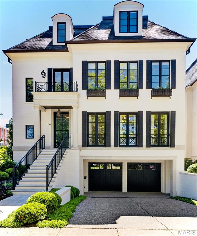Experience elevated living in this exemplary residence in the heart of Clayton, just minutes from dining, shopping and the business district. Situated on .27 acres, the property offers an exceptional amount of outdoor space in one of Clayton's most desirable locations. Designed and built by Slavin Homes, this four-bedroom, three-story home showcases exceptional craftsmanship and thoughtful attention to detail throughout; with custom millwork, hardwood flooring, custom cabinetry, and finishes that blend luxury with everyday livability.

The top-of-the-line Kitchen, appointed with premium appliances and every modern amenity, flows seamlessly into the Hearth Room, Breakfast Room, Bar Area, and open Porch; creating inviting gathering spaces ideal for both daily living and entertaining. The Living Room and Dining Room offer the ultimate in sophistication, and provide the perfect backdrop for elegant dinners and special occasions. The home features 10-foot ceilings on the main and second levels, while expansive windows fill the interiors with abundant natural light. The Primary Suite serves as a private retreat with a luxurious bath and two spacious walk-in closets, while the additional second-floor bedrooms each offer en suite baths.

The third floor adds exceptional flexibility with 9-foot ceilings, a large multipurpose room, fourth bedroom, and two additional baths. The lower level includes a finished living area, half bath, and walnut wine cellar ideal for collectors and entertaining, along with ample unfinished storage space. Additional highlights include a rare four-car garage, elevator, and outdoor living area with a fireplace that opens to the spacious back and side yards. Situated on a beautifully landscaped lot, the property offers an expansive outdoor setting rarely found in this area of Clayton.

Included in the sale is 140 N. Brentwood an additional .139 acres, further enhancing the privacy, outdoor space, and overall setting of this rare offering in the heart of Clayton.