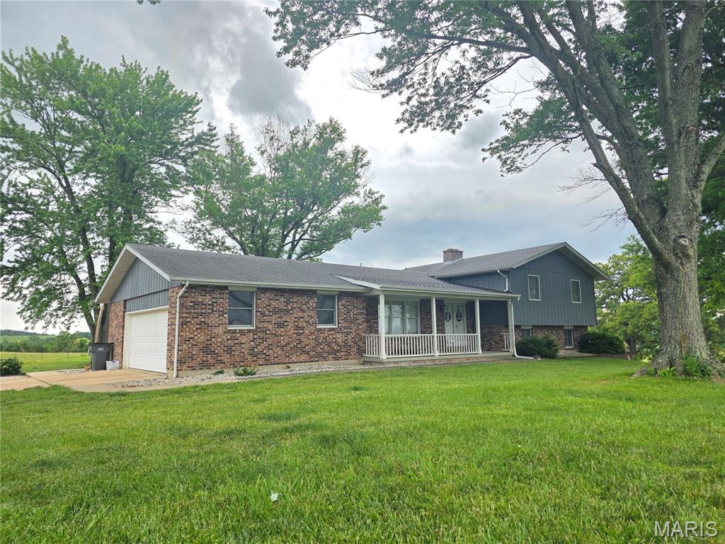 Welcome to 20962 Gisi Rd in Ste. Genevieve, where comfort, practicality, and country-style living come together in this spacious split-level brick ranch home. A 4-bed/3.5 bath brick ranch home in Ste Genevieve with acreage, multiple workshop spaces, and modern energy-efficient features, this home offers nearly 3 acres, over 3,100 square feet of living space, multiple gathering areas, extensive storage, and flexible indoor-outdoor living, all in a quiet location near town within the Ste. Genevieve School District.
Recent remodeling include updated flooring and an extra bath and the two separate family rooms create plenty of space. Wood-burning fireplace adds warmth and character, while the large sun room provides the perfect spot to enjoy peaceful views of the property year-round. A walkout patio creates seamless outdoor living and the convenient mudroom entry helps keep daily life organized. Additional features include basement storage and attic storage available in both the garage and shop areas for even more functionality. Outside, the property truly stands out with an oversized attached 2-car garage, a large detached shop complete with an additional loading dock, and a second smaller workshop. The large garden area, fruit trees and chicken coop offer excellent opportunities for buyers looking to enjoy a small homestead lifestyle. Solar panels installed in 2023 add energy efficiency and long-term savings potential. Situated on nearly 3 acres in a quiet setting near Ste. Gen, this property offers an ideal balance. Call or text today to schedule your private showing.