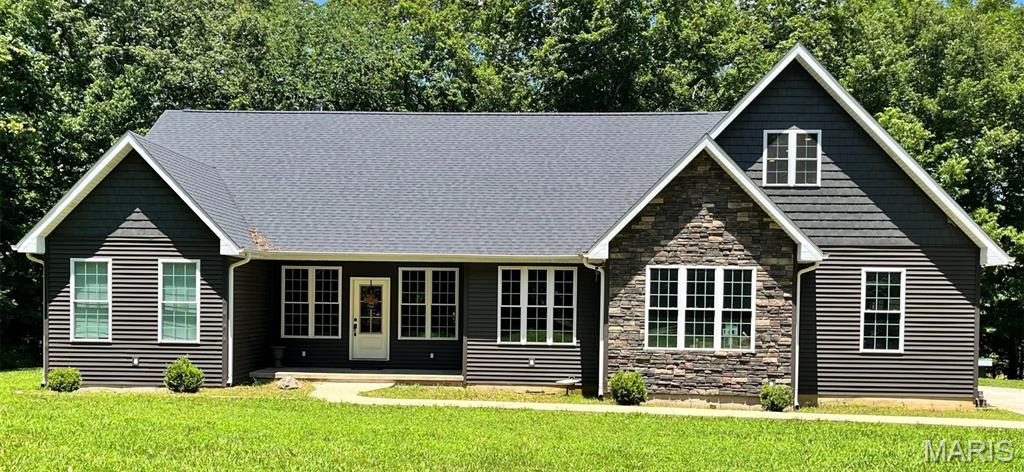 Custom built home situated on 3.5 acres m/l of wooded, peacefulness and seclusion. Attached 2-car, insulated garage. Covered front porch brings you into an open floor plan, living room, kitchen and dining area. Vaulted ceilings and cozy, wood burning fireplace and patio doors leading to a covered porch and open deck, The perfect spot for overflow entertaining. Kitchen with large island, lots of cabinet space, black stainless-steel appliances and custom built-in table and bench seating surrounded by windows.  Spacious pantry with built-in cabinets and shelving. Split bedroom floor plan. Primary bedroom has a full bath, separate walk-in closet and laundry room combo, safe room/storm shelter and French doors to porch and deck. Full bath and 2 additional bedrooms on opposite end of the house. Upstairs bonus rooms could be additional bedrooms, guest rooms or rec rooms. One room has 3/4 bath, built-in cabinets and bench. This house has lots of great space with plenty of room for your family. Acreage is all wooded with room to add that shop building or garden.
