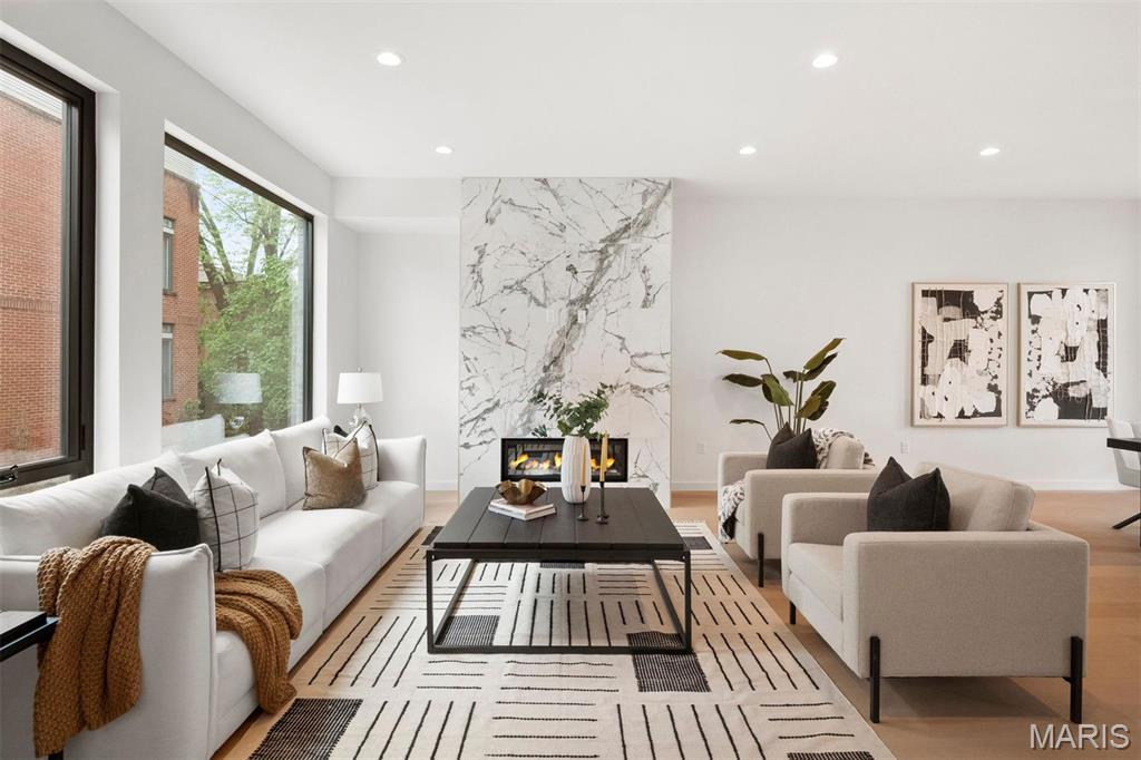Urban living without compromise at Artizen on West Pine! This sophisticated residence offers the ultimate in upscale city living just steps from the heart of the CWE. A dramatic interior welcomes you with soaring 10’ ceilings, wide-plank wood flooring, and curated designer lighting throughout. The sun-filled open floor plan features a spacious living and dining area anchored by a sleek gas fireplace and expansive picture windows with custom shades. The chef’s kitchen is a true showpiece, showcasing JennAir appliances, a statement quartz island, gas cooktop, built-in pantry, and direct access to a private 12x14 terrace—perfect for indoor-outdoor dining and entertaining. Upstairs, the primary suite impresses with a spa-inspired bath featuring a floating double vanity, glass-enclosed shower, soaking tub, and walk-in closet. Two additional bedrooms, a full bath, and a custom wet bar open to a second private terrace. The lower level adds versatility with a den or office, full bath, and a rare three-car garage. Enjoy the space and comfort of a single-family home paired with low-maintenance townhome living in one of the CWE’s most coveted communities. An exceptional condo alternative and move-in ready!