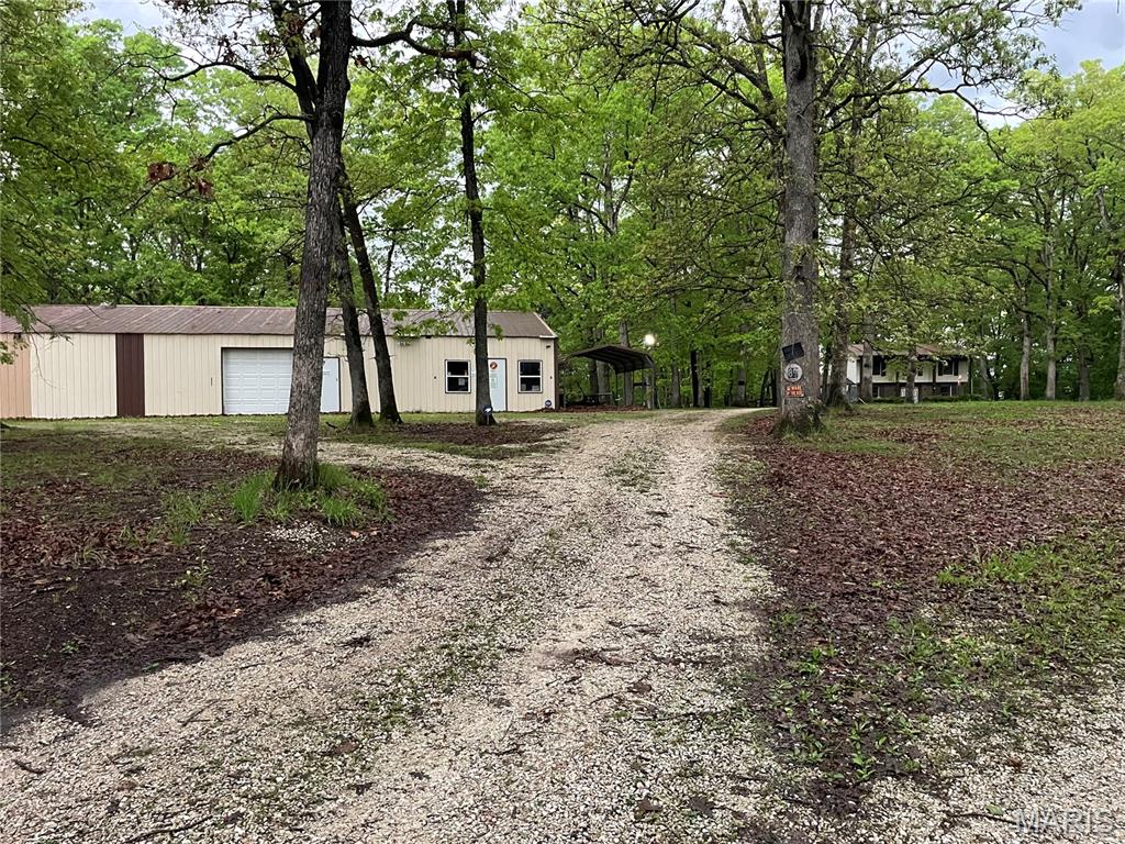 Escape to approximately 60 acres of rolling, fully wooded terrain offering exceptional recreational value, privacy, and investment potential. This remarkable property features heavy woods, suitable for riding trails and pond sites, a dedicated shooting range, and abundant wildlife, making it an ideal retreat for hunters, outdoor enthusiasts, or those seeking a secluded getaway. Enhancing the property's versatility is a two-story residence offering 3 bedrooms and 2 bathrooms with a brick front and vinyl exterior. The home includes an attached one-car garage. Home is being sold in as-is condition. A standout feature is the impressive 40' x 80' climate-controlled metal outbuilding, complete with two overhead doors and two service doors, perfectly suited for equipment storage, a professional workshop, hobby space, or an ultimate gathering place after a day in the woods. Whether you're searching for a private hunting preserve, weekend retreat, future homestead, or long-term land investment, this unique property offers endless opportunities.