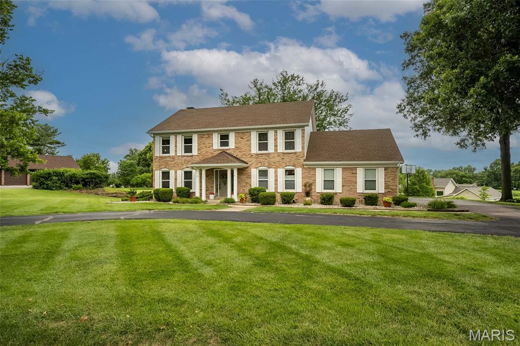 Welcome to this stunning two-story home tucked inside a private gated enclave, perfectly situated on a picturesque one-acre lot that offers both serenity and space. Boasting over 2,800 square feet above grade and more than 3,500 square feet of finished living space, this home is the perfect blend of thoughtful design, modern updates, and everyday functionality. The beautifully remodeled main level is sure to impress, highlighted by a show-stopping kitchen designed for both entertaining and daily living. Featuring custom cabinetry, a large center island, expansive counter space, and an adjoining breakfast room, this space is truly the heart of the home. A well-appointed butler’s pantry adds convenience and extra storage, while the oversized mudroom/main floor laundry area elevates organization with additional custom cabinetry, a second sink, and even a second full-size refrigerator.  Rich hardwood flooring flows throughout the main level, complementing a spacious family room with built-in shelving and a cozy gas fireplace. A generous flex room provides versatility for a home office, formal dining, or additional living space to suit your needs. Upstairs, retreat to the vaulted primary suite, a true sanctuary featuring dual closets and a beautifully remodeled ensuite bath complete with a large walk-in shower, striking vessel tub, and double vanity. Three additional bedrooms and a full bath offer ample space for family, guests, or hobbies. The walk-out lower level expands your living options even further, offering an additional family room, a sleeping area, and a full bathroom—ideal for guests or extended living arrangements. This home is as practical as it is beautiful, with high-efficiency HVAC and water heater, plus a roof that’s only six years old for added peace of mind. Step outside from the sunroom to a sprawling patio with a pergola, creating the perfect setting for outdoor dining, entertaining, or simply enjoying the tranquility of your private acreage. As part of this exceptional gated community, you’ll enjoy access to 7 scenic lakes and walking trails, offering a lifestyle rich with nature and recreation. This is more than a home—it’s a retreat. Don’t miss the opportunity to make it yours!