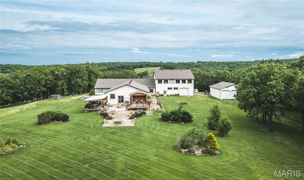 Located in the heart of Missouri Wine Country near the historic town of Hermann, this extraordinary 376+- acre estate in Gasconade County offers one of the largest contiguous tracts available in the region. Combining luxury living, productive farmland, premier recreation, and extensive infrastructure, the property is ideally suited as a private family estate, corporate retreat, hunting lodge, equestrian operation, cattle farm, short-term rental/VRBO/Airbnb, event venue, or business headquarters.

Surrounded by the rolling hills of central Missouri, the property features breathtaking views, established pasture, mature timber, water features, and convenient access to the Missouri River corridor and Hermann wine region. The balance of open ground and wooded habitat provides outstanding deer and turkey hunting while maintaining excellent agricultural utility.

At the heart of the property is an impressive 10,000+- sq ft total living space lodge with 5 bedrooms and 9 bathrooms. Designed for entertaining, it features expansive gathering spaces, including a 1,600+- sq ft great room and matching four-season room with soaring vaulted wood ceilings and panoramic views overlooking the private 2+ acre lake. The oversized kitchen offers abundant prep space, seating, and room for large gatherings.

The resort-style setting includes the stocked 2+ acre lake with a sandy beach, swim platform, elevated pavilion, and excellent fishing. Groomed ATV and horseback trails wind throughout the property, connecting wooded ridges, creek bottoms, and pastures. Additional amenities include a full-size soccer field, elevated hunting cabins, and numerous established stand locations.

Guests are accommodated by additional living quarters, including a renovated two-story red barn with approximately 2,500+- sq ft of finished living space featuring a bedroom, bathrooms, and recreation area, plus a separate 3-bedroom, 2-bath guest home—ideal for family, staff, hunting groups, or corporate retreats.

Agricultural improvements include three fenced cattle pastures, approximately 50+- acres of productive hay ground, orchards, gardens, cattle barns, and multiple utility buildings. Additional improvements include a 7,200+- sq ft pole barn, 1,400+- sq ft heated and cooled tool shop with four garage doors, attached 3,000+- sq ft heated garage, separate 2,000 +- sq ft heated utility workshop, kennel facilities, gazebos, storage buildings, and equipment sheds.

A dedicated 3,000+- sq ft office building includes conference space, private offices, open work areas, dual satellite systems, and DSL service, making the property well suited for a remote business headquarters or corporate campus. Two Generac generators and dual outdoor wood furnaces provide dependable backup power and heating for the home, office, and garages.

The property also offers exceptional future potential with an ideal location for construction of an additional 25 acre lake. Its combination of water, timber, pasture, and rolling topography creates year-round opportunities for hunting, fishing, horseback riding, ATV recreation, livestock production, farming, and outdoor entertaining.

Located within the Gasconade County R-1, Hermann School District, the property offers convenient access to wineries, river recreation, shopping, dining, and tourism while maintaining outstanding privacy. Properties of this size and caliber are rarely available in Missouri Wine Country, especially with this blend of luxury improvements, agricultural utility, recreational diversity, and income-producing potential.

Whether you're seeking a premier Missouri hunting property, luxury country estate, corporate retreat, equestrian operation, or legacy family compound, this remarkable 376+- acre property offers unmatched versatility in one of Missouri's most desirable rural regions.