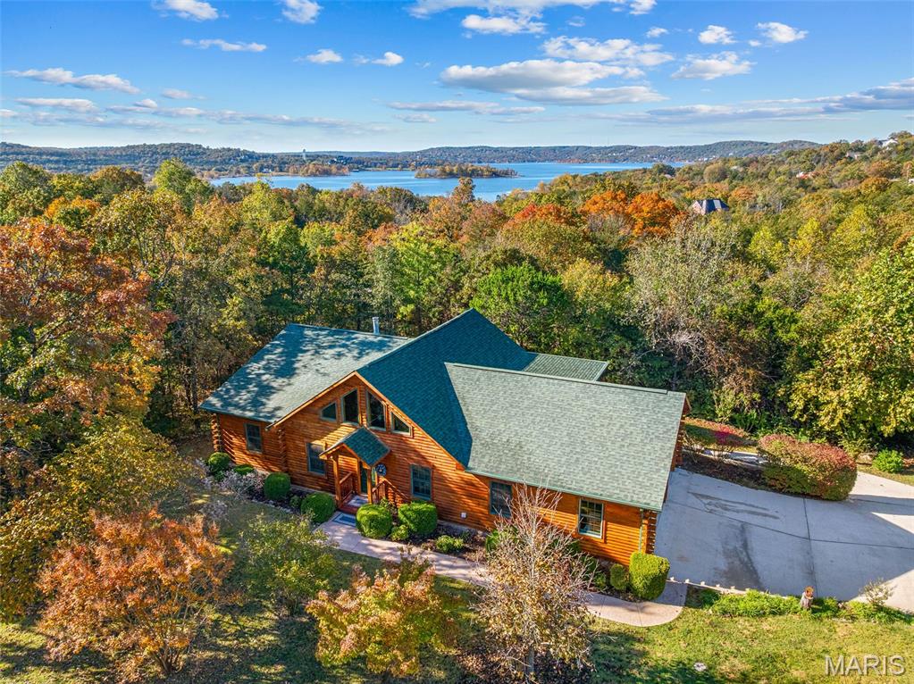 Custom Oak Log Home in Gated, Prestigious Emerald Pointe. Over 3500 sq ft on a 1.67 acre, Private, Wooded, Level Lot in One of the Best Table Rock Lake Neighborhoods. This Home Truly Offers the Best of Both Worlds......Privacy & Easy Lake Access. Superior Constructed Oak w 2 Levels of Living. Does it Have a Lake View, No.....But the Wooded Privacy Lends Itself to the Perfect Log Home Setting, WITH all the Fabulous Lake Amenities Right in the Neighborhood.  Large Yard is a Canvas for Your Gardening Delight, Open Floor Plan. Kitchen w Stainless Appliances, Butcher Block Counters & So Much Cabinet Space. Main Level Primary Bedroom Suite Featuring Luxury Walk In Tiled Shower, Whirlpool Tub & Huge Walk In Closet. Main Floor Laundry. Some ADA features on Main Level. Walk Out Lower Level with Additional Bedrooms, Family Room, Kitchenette & Storage. Spacious Covered Deck Where You'll Enjoy Soaking in Nature All Around You, and Be Entertained by the Abundance of Wildlife. Three Car Garage. Impressive Gated Community Amenities Include a Marina that Offers High & Dry Service & Storage w Courtesy Dock, Boat Ramp, Clubhouse, Pool, Pickleball, Tennis & Basketball Courts. Emerald Pointe has Quick Highway Access & Conveniently Located to Dining, Shopping, Entertainment, Medical Care, etc., Along with Several of the Top Golf Courses in the USA, Big Cedar Lodge, Branson Landing, Silver Dollar City, and All the Entertainment & Shopping Branson has to Offer is Within Minutes! Begin Living Your Best Lake Life Today in This Charming Log Home....Truly the Best of Both Worlds....Incredibly Priced in Emerald Pointe, Where Many Homes Sell for Over $1Mil.  Come Take a Look For Yourself Today! BONUS: Adjoining Lot is Also Available, Giving You the Opportunity to Have 2 Acres of Your Own Private Lake Paradise!