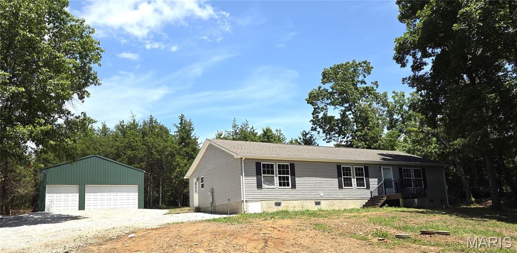 Move in ready 3 large bedrooms with walk in closets, 2 full baths on 1.9 private act out of town.  This home offers it all... enter from the new front porch into the oversize living room with an open floor plan to the separate dining room with built in cabinetry, large kitchen with breakfast bar and walk-in pantry, don't forget the main floor laundry room and side entry door.  The split floor plan provides 2 large bedrooms with walk-in closets and a full bath on one end of the home and the private primary suite is on the other.  Primary offers a large walk-in closet and private ensuite with soaking tub, separate showing and separate vanities.  The new luxury flooring in the home and freshly painted walls makes it ready to move right in.  The 25 x 30 Metal detached 3 bay garage is insulated, has electric, concrete flooring, a large workspace and man door on side.  (car lift can stay but is as is & will need work).  Don't forget the large front and back yards.  New front porch and a large patio in the back on your private 1.9 acres.  The improved driveway and large parking area makes it great for all your family and guests to visit.  Don't miss this one.  The home was built under the IRC International Residential Code which is used for modular homes by Clayton Homes of Kentucky.