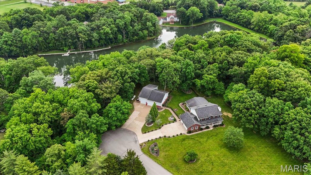 BEAUTIFUL, CUSTOM 1.5 story WATERFRONT home on 3+/- level/sloping acres in Lake St. Louis! This 4 bed, 4 full & 1 half bath home with 4,640+/- sq ft of living space offers an AWESOME, heated/cooled detached garage (50 AMP, RV fits, full bath, washer/dryer) in addition to the attached 3-car garage. Covered front porch greets you as you step inside the entry foyer. Updated, professional kitchen with custom cabinetry, Quartz countertops, center island, stainless steel appliances & leads to a breakfast room with a custom butler’s pantry. Primary suite with tray ceiling & a luxury custom bath boasting a double sink vanity, large walk-in custom closet, laundry room, shower & jet tub. Family room/office with a gas fireplace, dining room, living room & sunroom with a walk-out to backyard completes the main level. Upper level extends living with secondary primary bedroom with 10' vaulted ceiling, large walk-in closet and an updated bath with shower & soaking tub. 2 Additional bedrooms that share hall remodeled bath & secondary laundry room. Lower-level has additional living space with 1,200+/- sqft, full bath, rec/family room, walk-in closet & storage room. Outside one will enjoy a stunning level fully fenced in backyard, a stone/brick patio w/remote awning & a walkway from to lake access. Conveniently located in the Wentzville School District and quick access to major highways, dining, shopping, etc. *Horses allowed on property* MUST SEE!