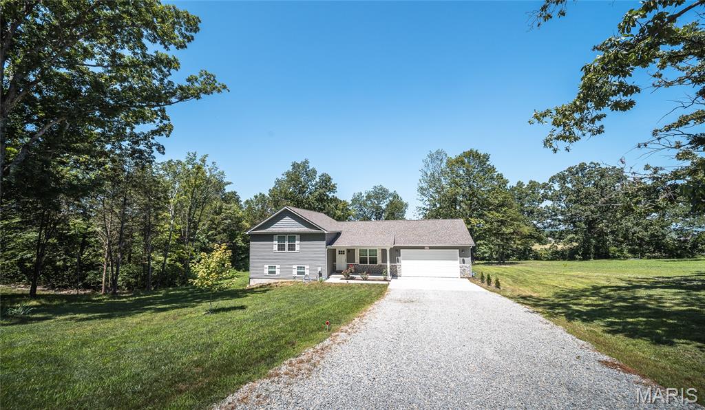 Welcome to your own private retreat where modern comfort meets breathtaking country views. Built in 2024, this stunning tri-level home offers approximately 2,000 square feet of thoughtfully designed living space, making it easy for everyone to enjoy their own place to relax while still coming together in the heart of the home. Whether you're watching the vibrant fall foliage, enjoying peaceful spring mornings, or taking in a fresh blanket of snow from the covered deck, the panoramic views provide a beautiful backdrop in every season. The spacious great room is perfect for entertaining, seamlessly flowing into a stylish kitchen featuring trendy cabinetry, gleaming granite countertops, and a full suite of appliances. With four bedrooms and three full bathrooms, there's room for family, guests, or a home office. The expansive lower-level family room offers endless possibilities and could easily serve as a private primary suite, recreation space, or media room. Located just outside of town, you'll enjoy the serenity of country living without sacrificing the convenience of nearby shopping, dining, schools, and everyday amenities. It's the perfect balance of peaceful surroundings and modern accessibility. If you've been searching for a newer home with incredible views, flexible living space, and move-in-ready finishes, this one checks every box. Schedule your private showing today and experience everything this exceptional home has to offer!