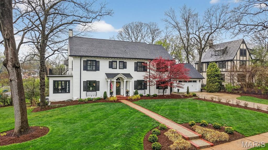 Welcome to this stately Webster Groves home, ideally positioned on a corner lot with added privacy and a beautifully landscaped front yard. The curb appeal reflects the extensive exterior upgrades, including LP Smartside siding and newly installed windows.  Inside, a center hall floor plan welcomes you with hardwood flooring and tasteful finishes throughout. The living room offers a wood-burning fireplace and a comfortable setting suited for both quiet evenings and hosting guests. Just off this space is a versatile room that works well as a den or office.  Across the entry, the dining room features built-in china cabinets and abundant natural light. The adjacent kitchen has been thoughtfully updated with custom cabinetry, high-end appliances, tile flooring, a classic subway tile backsplash, and a large island with quartz countertops.  A sitting area off the kitchen opens directly to two patios, creating an easy indoor-outdoor flow. The outdoor kitchen is equipped with a refrigerator, gas grill, side burner, and the perfect spot for a smoker, making it ideal for gatherings and entertaining. There is also a two car garage located, conveniently, right off the side entrance.  Upstairs, you’ll find four well-proportioned bedrooms, including a primary suite with a full bath featuring a double vanity and a fully outfitted walk-in closet. The remaining bedrooms offer ample closet space and share an updated hall bathroom.  The lower level stands out among homes in Webster Groves, offering a kitchenette, a temperature-controlled wine room, and a half bath—perfect for casual entertaining or movie nights.  This home has been meticulously maintained, with care evident throughout. Be sure to review the full list of features and updates.  In addition to the incredible features this home has to offer, the location is unbeatable. Sherwood Forest is a highly sought-after Webster Groves neighborhood and walkable to schools, restaurants, ice cream shops, parks and so much more.