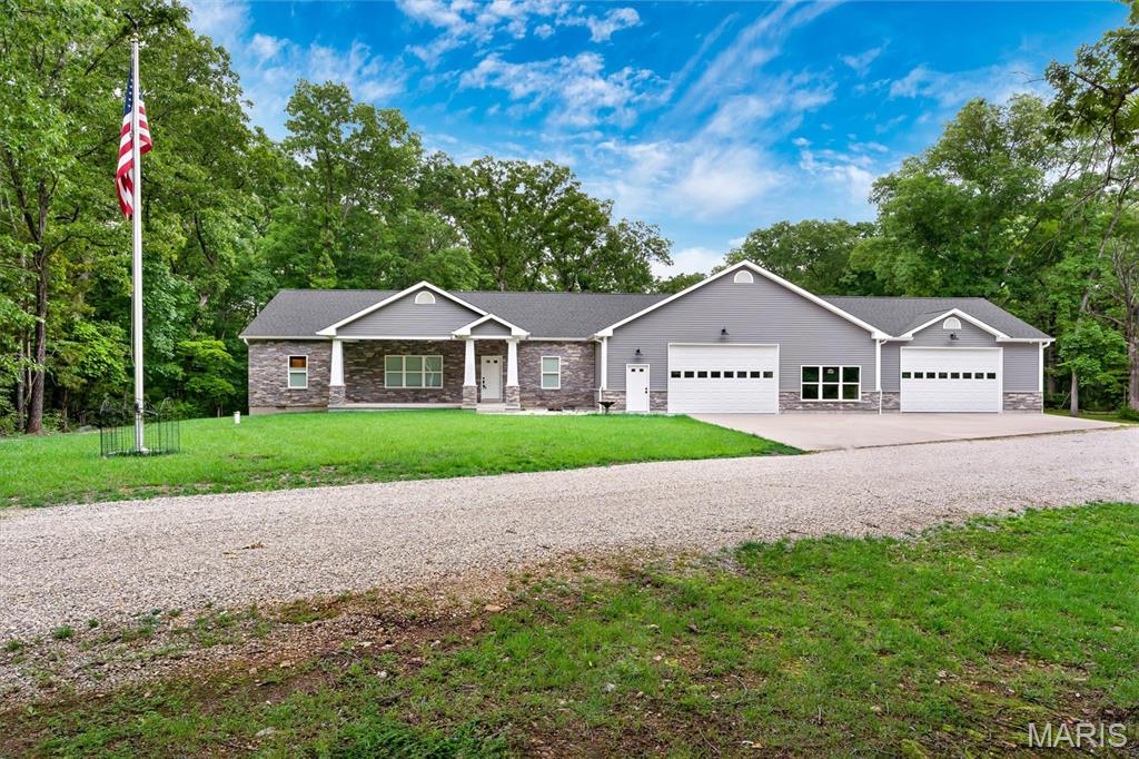 Hard to find, custom-built, top-of-the-line SHOUSE with room to expand! This thoughtfully designed home blends the comfort of a traditional residence with the functionality of an attached 60x40 shop and 30x28 garage, all wrapped in upgraded siding and stone veneer for a beautifully finished exterior.

Step inside to a spacious open-concept great room with 10-ft vaulted ceilings and LED lighting. The kitchen features custom soft-close cabinetry, a 4×9 cultured-marble island, cast-iron farm sink, tile backsplash, stainless appliances—including a 36” propane range, four-door fridge, under-cabinet microwave, and full-size ice maker—and under-cabinet lighting throughout.

Down the hall, the primary suite offers a double-bowl vanity, marble-tile flooring, a large walk-in shower with glass door, and a custom walk-in closet with maple built-ins. Additional bedrooms include carpeted floors, ceiling fans, and convenient access to the full bath. Laundry is nearby with front-load machines included.

This home was built with a true foundation and insulated crawlspace, not a slab. It features concrete footings and foundation walls, a 2x12 framed sub-base, and ¾” tongue-and-groove flooring. The crawlspace is fully insulated—including spray-foamed band boards—with a vapor barrier, gravel base, and a safety-vented duct to prevent freezing of water lines. Drain tile runs the full length of the home and exits to daylight, and most downspouts are piped underground to keep water away from the foundation and prevent ice buildup on walking surfaces.

The attached shop and garage offer exceptional versatility with tall ceilings, insulated overhead doors, LED lighting, metal wall panels, and space for vehicles, equipment, ATVs, and more. There’s also a 50-amp RV hookup with septic connection, a 16x10 insulated outbuilding with electric on its own concrete pad, extensive parking, a gravel RV pad with retaining wall, and a 30’ commercial flagpole.

Additional upgrades include spray-foam insulation, 400-amp service with buried electric, tankless water heater, water softener, and dual heat-pump systems. Only three steps connect the shop to the home for easy access.

A rare opportunity to own a high-quality, custom shouse with unmatched workspace, thoughtful construction, and modern comfort.