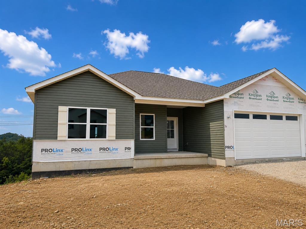 COMING SOON! HOME IN PROGRESS! #UNIONMO. A divided 3x2 ranch plan on a nice corner lot that backs to woods.  This one shows off a grand kitchen with an oversized island, a large composite sink & breakfast bar, loads of white cabinets, awesome granite tops, LVP floors, stainless front microwave & dishwasher, main floor laundry near primary suite & more. Glass slider door in the dining room to a nice 12’x12’ composite deck with white vinyl rail system. Soaring 9' interior house walls throughout. A lovely entry with a large coat closet, door to garage & door to lower level nearby. Primary with a large walk-in closet, oversized double bowl vanity, gorgeous walk-in shower with glass slider door & more. The secondary beds are a nice size & share a full hall bath with a tub/shower & vanity. Very spacious walk-out basement with full bath rough-in & more. The exterior combo of stone against a light green color siding, a large front porch, white accents, and white garage door with glass windows is amazing. ELS HOMES - LOCAL BUILDER AT ITS FINEST - #ELSHOMES