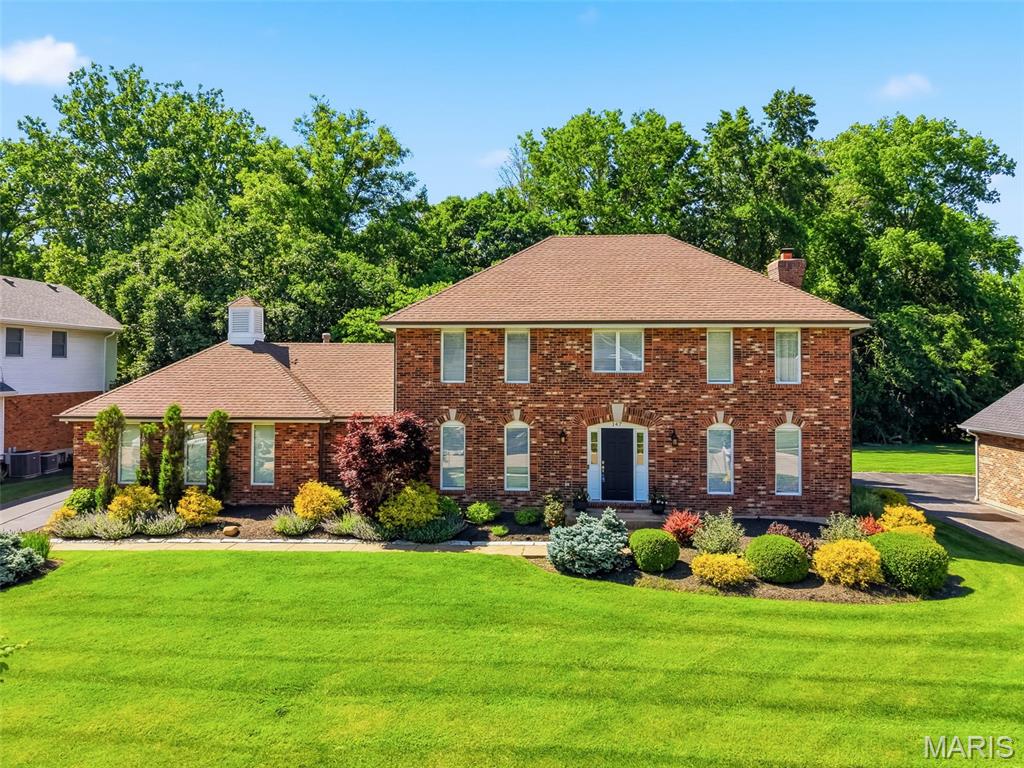 Welcome to your next home where casual elegance and style blend effortlessly in this stunning Green Trails Country Club Grounds home in sought after Parkway Central Schools.  With over 3,400 square feet of living space, this home exudes timeless style and everyday comfort.  Exceptional curb appeal welcomes you with mature landscaping, landscape lighting and an inviting entry. Warm wood flooring spans the main level.  The well designed kitchen features a center island, 42" cabinetry, granite countertops, updated stainless steel appliances, double oven, induction cooktop, built-in pantry and task desk provide additional cabinetry for storage.  The adjoining breakfast area flows into the light-filled sunroom with double french doors, vaulted ceiling with fan and skylights. Enjoy easy access to the expansive patio and yard lined with mature trees for added privacy. The family room offers crown molding, 5-window bay, built-in bookcases flanking the a gas fireplace with brick surround and wood mantle. The bar with beverage fridge makes it easy to entertain! Elegant living and dining rooms showcase decorative wainscoting and crown molding with continued neutral color palette. Completing the main floor are a powder bathroom and a convenient main floor laundry and mudroom with functional built-in storage cubbies and utility cabinets off the rear-entry garage which includes a 220 outlet on a 50 amp breaker ready for EV charging.  Upstairs, the spacious primary suite is filled with natural light and includes a professionally organized shelving system in the walk-in closet and updated primary bath with dual sink vanity, soaking tub, and separate shower. Three additional bedrooms also feature organized closets and share a freshly updated hall bath with dual sink vanity and zero-entry walk-in shower. The finished lower level provides additional living space with a large recreation room, full bath with shower, and versatile bonus room ideal for a home office, guest space, or workout area. Dual zoned HVAC for added efficiency.  Set on an almost 1/2 acre level lot backing to trees, in-ground sprinkler system and paver patio, this is the home you have been waiting for. The backyard offers privacy and open space in a peaceful outdoor setting. Conveniently located close to schools, dining, grocery, shopping and interstate. Welcome home!