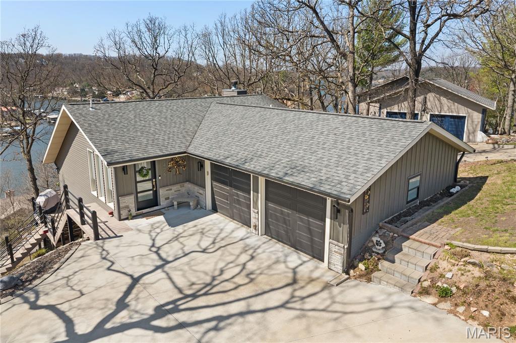Discover this immaculate 2nd-tier ranch in Linn Creek, boasting spectacular panoramic views of the 29.5 MM. Far from a "cookie-cutter" home, this 3-bedroom, 3-bathroom residence is bursting with style, character, and extensive high-end updates inside and out. The exterior features a newer roof with leaf guards, newer siding, windows, and a fresh concrete driveway. Relax on the deck under a beautiful pergola or enjoy the professionally landscaped yard with a sprinkler system and a fenced dog run. Inside, the home shines with quartz countertops, custom cabinetry, new appliances, fresh flooring and paint throughout. All three bathrooms have been gutted and remodeled, including a luxury master en-suite with a new soaker tub and custom walk-in shower. For ultimate comfort, the master suite includes its own dedicated furnace and water heater. Cozy up to the wood-burning fireplace in the winter or enjoy lake views from the master and living areas year-round. Modern mechanicals include a new heat pump and water softener. With a 2-car garage, extensive parking for guests or toys, NO HOA, & rentals allowed, this move-in-ready gem offers total freedom. Your perfect lake-view lifestyle awaits!