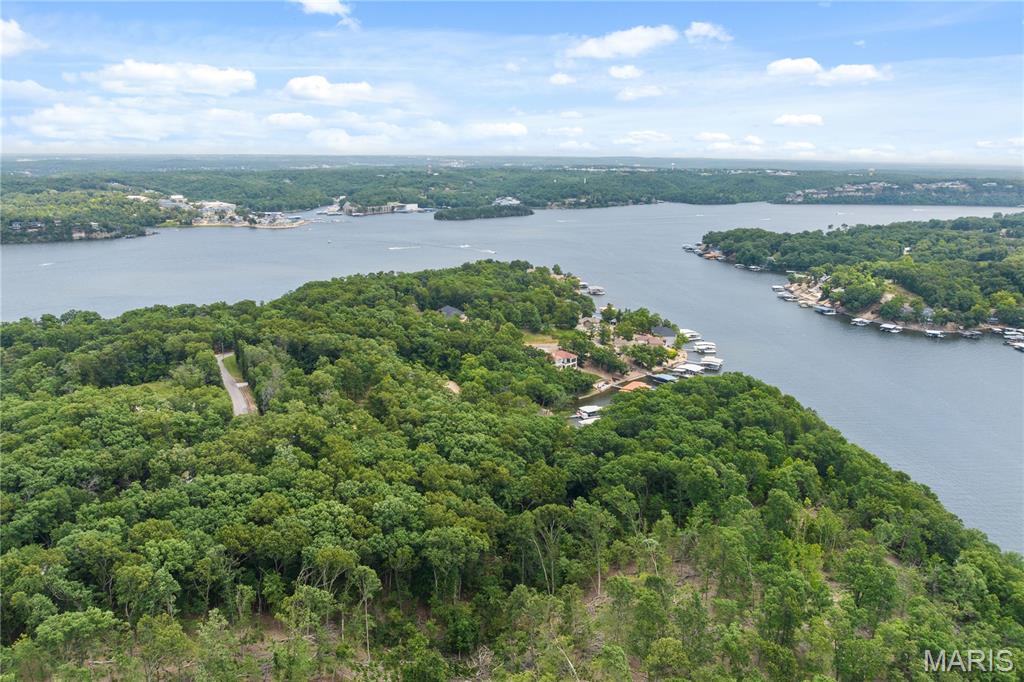 PRIME LAKEFRONT DEVELOPMENTOPPORTUNITY | 9.26 ACRES | 1,250’ OF SHORELINE! An extraordinary & increasingly rare offering at the 26 MM in Sunrise Beach—this remarkable 9.26-acre lakefront property boasts approximately 1,250 feet of pristine shoreline, creating a commanding presence on the water w/panoramic, unobstructed views. Tucked away in a protected cove with calmer waters, the setting delivers peace & privacy while remaining just minutes from premier dining, shopping, & entertainment. Positioned just prior to an established enclave of high-end lake homes, this R-1 zoned tract presents exceptional versatility. Ideal for a luxury private estate, a legacy family compound, or a thoughtfully planned residential development, the property offers both road & water access, simplifying future construction & enjoyment. Large, buildable lakefront parcels of this size & shoreline depth are exceptionally scarce in today’s market, making this a standout opportunity for developers. Whether your vision is a signature lakefront residence or a strategic investment in one of the lake’s most desirable corridors, this property delivers location, scale, & unmatched potential at the Lake of the Ozarks.