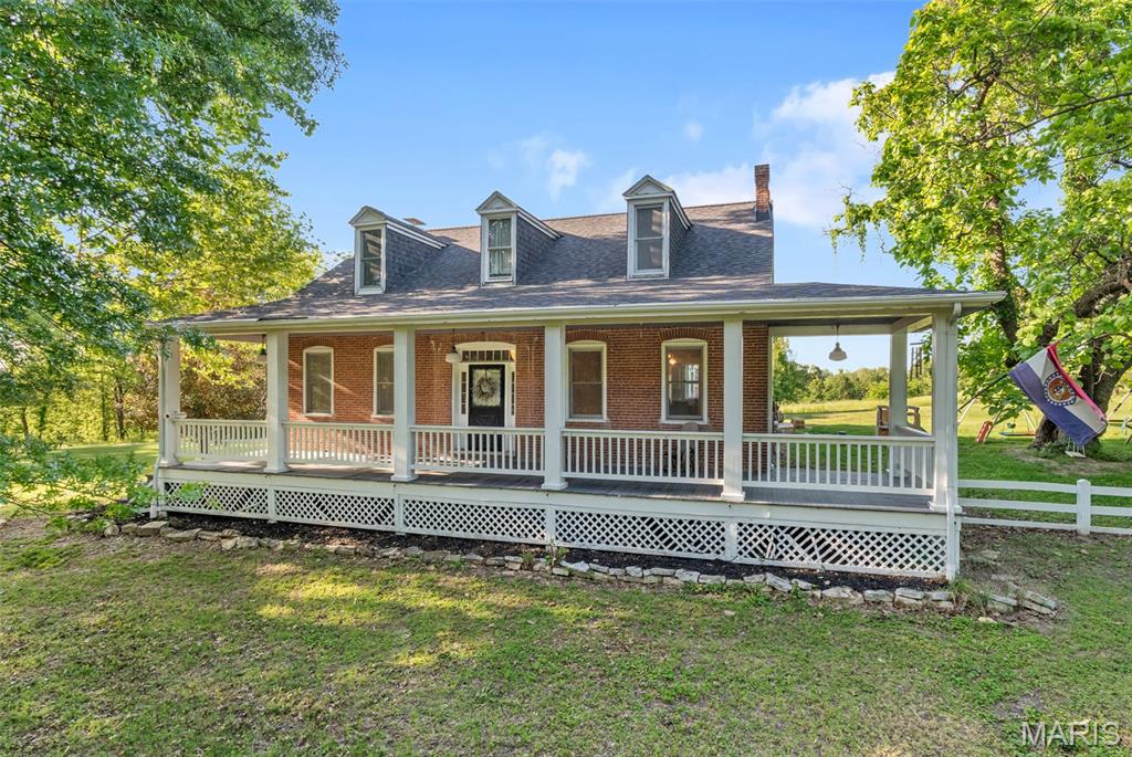 Welcome to a rare blend of historic elegance, peaceful country living, and modern day comfort. Built in 1883 and situated on 5+/- picturesque acres, this beautifully maintained brick and frame home is filled with timeless character and unforgettable curb appeal. Surrounded by mature shade trees and highlighted by a stunning wraparound front porch, this property immediately feels like home from the moment you arrive. Whether you are enjoying your morning coffee while watching the sunrise or relaxing in the evening with family and friends, the expansive porch creates the perfect setting to slow down and enjoy country living at its finest. Inside, the home showcases oversized rooms, soaring ceilings, and the kind of craftsmanship and charm that simply cannot be recreated. Rich with warmth and personality, every space offers a unique blend of historic detail and thoughtful modern updates. The spacious eat in kitchen opens seamlessly into the bright and inviting sun room, making it ideal for entertaining, gatherings, or simply taking in the peaceful views of the surrounding property.
The second level features three generously sized bedrooms and two full bathrooms, offering comfort and flexibility for families, guests, or even a private home office setup. Throughout the home, recent improvements and tuck pointing provide added confidence while preserving the integrity and beauty of this historic property. Step outside and discover endless possibilities. The large pole barn offers ample space for storage, hobbies, equipment, or recreational use, while the open acreage is perfect for animals, gardening, outdoor entertaining, or simply enjoying the privacy and beauty of your own slice of countryside.
Properties like this rarely come available. With its rich history, welcoming atmosphere, scenic setting, and countless updates, this one of a kind home offers the perfect combination of charm, space, and functionality. Experience the beauty, character, and peaceful lifestyle this extraordinary property has to offer. Schedule your private showing today before this incredible opportunity is gone.