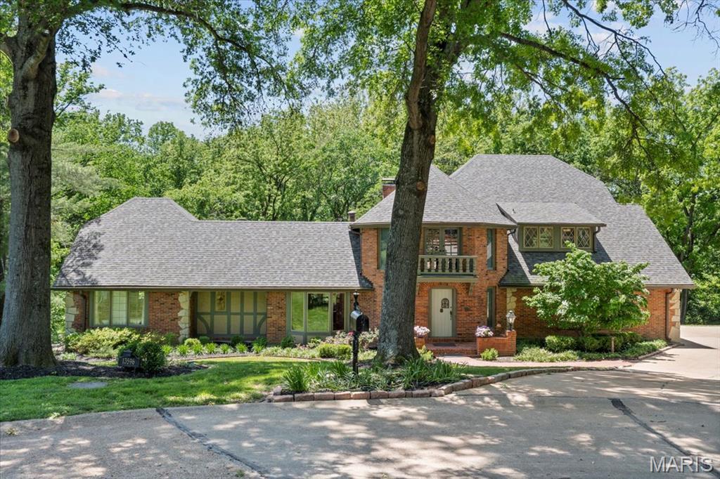 Tucked away on a serene cul de sac with direct access to Queeny Park, this extraordinary home is truly one of a kind. European-inspired architecture and exquisite carved woodwork give it distinctive character and old-world charm. First impressions are everything, and the grand entry foyer does not disappoint with its turret ceiling and view of the dramatic great room with beamed cathedral ceiling and rich wood paneling. The renovated kitchen is a chef’s dream, featuring knotty alder cabinetry, dual center islands, and pale Brazilian marble countertops—both beautiful and functional for everyday living and entertaining. Nearly every window frames views of lush woods, inviting the outdoors in. The owner's suite is a private retreat designed for relaxation--complete with a cozy sitting room, balcony overlooking the scenic property, and a remodeled luxury bath. Upstairs you will find 3 generously sized bedrooms--each with unique details, and a spacious bath. Convenience abounds with both main floor and second floor laundry rooms. The finished lower level offers rich, speakeasy vibes—ideal for entertaining with an impressive bar, billiards room, and plenty of space to gather. Guests will feel truly pampered with their own private space complete with a bedroom, full bath, and convenient kitchenette—perfect for extended stays or visiting family. Whether you’re hosting guests or enjoying quiet time, this special property offers a rare blend of elegance, comfort, and natural beauty.