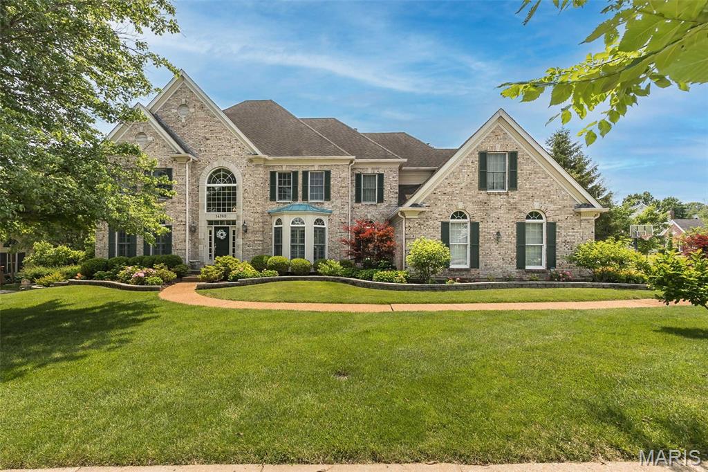 Classic-styled brick 2-Sty in premier neighborhood. This former Jones display features an open floor plan with oak hardwoods, detailed trim work, Palladian windows & plantation shutters. Impressive 2-sty entry foyer leads to private study, formal dining room with wide bay window & library-paneled great room with box beam ceiling, wet bar & marble fireplace flanked by built-in bookcases. Chef’s kitchen with 42” white cabinetry, KitchenAid  appliances, 4’ center island & butler’s pantry adjoins light-filled breakfast room with convenient planning center & vaulted hearth room highlighted by brick fireplace. T-staircase accesses coffered primary bedroom suite with luxury bath with jetted tub & sitting room plus 3 additional bedrooms, 1 with ensuite bath & 2 with Jack n’ Jill bath. Walk-out Lower Level includes family room with entertainment center, wet bar, fireplace & office area plus 5th bedroom & full bath. Situated on a .5-acre lot with wrap around deck, covered patio & 3-car garage.