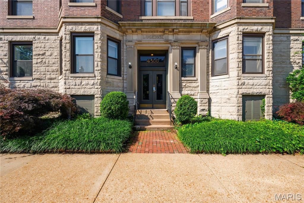 Welcome home to the historic Lucerne Condominiums, ideally located on McPherson Avenue in the heart of the Central West End. This charming 2-bedroom, 1-bath corner residence offers over 1,100 square feet of thoughtfully designed living space, blending timeless architectural character with modern updates.
The spacious living room is filled with natural light and features beautiful built-in bookcases and a wood-burning fireplace, creating a warm and inviting atmosphere. A formal dining room provides the perfect setting for entertaining, while the updated kitchen is equipped with 42-inch custom cabinetry, granite countertops, stainless steel appliances, and a pantry for added storage.
The generously sized primary bedroom offers a decorative fireplace and a peaceful retreat, while the second bedroom showcases a distinctive bay window that enhances the home’s historic appeal.  Both bedrooms can fit a king-sized bed. Insulated windows throughout the unit provide comfort and energy efficiency.
Conveniently situated just half a level above ground floor, this well-maintained home includes in-unit laundry, a private basement storage locker, and secure gated parking. The professionally managed HOA helps ensure a well-cared-for community and grounds.
Step outside the stately brick and limestone building and enjoy one of St. Louis’ most vibrant and walkable neighborhoods. Located just one block from Euclid Avenue, residents have easy access to acclaimed restaurants, cafés, boutiques, bookstores, galleries, and seasonal community events. The neighborhood farmers market, nearby cultural attractions, and close proximity to Washington University, Saint Louis University, and Barnes-Jewish Hospital make this an exceptional opportunity for anyone seeking an urban lifestyle rich in convenience and character.
Experience the perfect blend of historic elegance, modern comfort, and premier Central West End living.