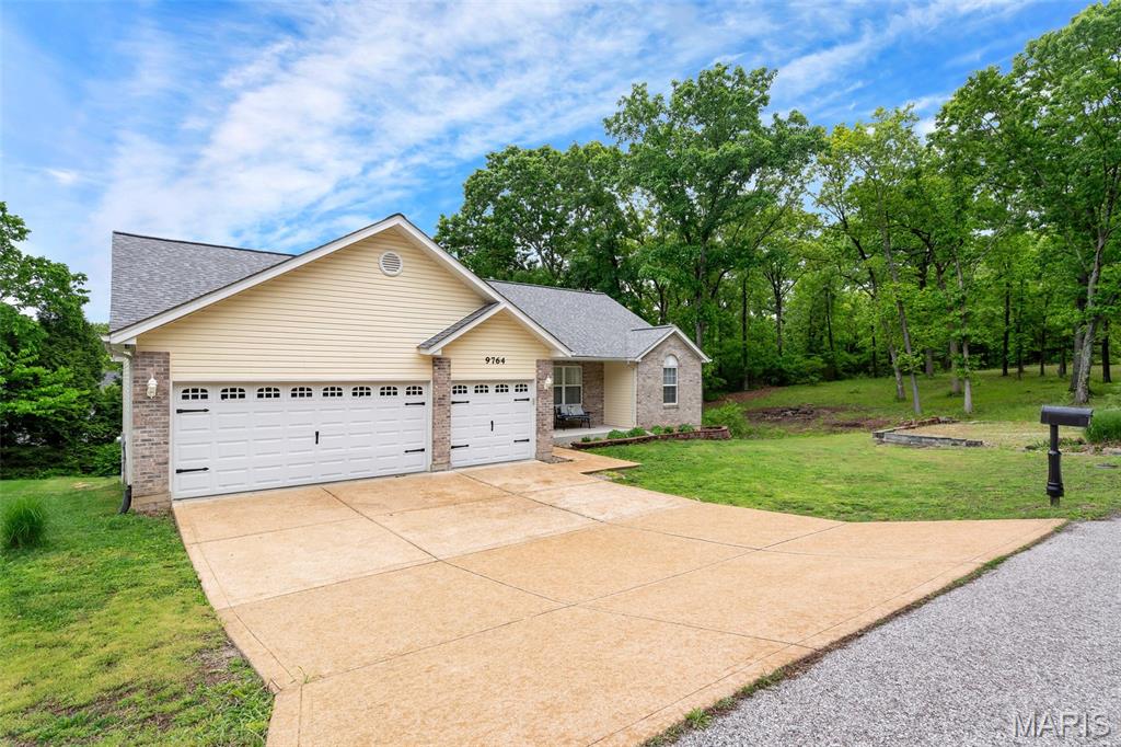 Set on a generous 0.69-acre lot in the desirable Raintree community, this beautiful brick-front ranch offers both space and style—plus access to the neighborhood lake and amenities. A welcoming covered front porch leads into an expansive, open-concept layout highlighted by a spacious great room with a striking cathedral ceiling that extends into the dining area and kitchen. The kitchen is designed to impress, featuring custom cabinetry, granite countertops, a ceramic tile backsplash. The primary suite provides a comfortable retreat with a large walk-in closet and a private bath complete with dual vanities, a soaking tub, and a separate walk-in shower. The finished walk-out lower level adds even more living space.  Rounding out the home is an oversized three-car garage, offering plenty of room for vehicles and storage.