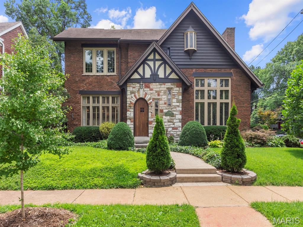Step into timeless charm in this enchanting Tudor storybook-style condominium, nestled in the highly sought-after University City Hills Subdivision. Rich in architectural character, this inviting home showcases beautiful hardwood floors, beamed ceilings, graceful arched doorways, and exquisite leaded glass and newer windows that create warmth and elegance throughout.
The spacious floor plan features two comfortable bedrooms and one full bath, along with a generously sized formal dining room that's perfect for entertaining. The bright eat-in kitchen offers granite countertops, abundant cabinetry, and plenty of space for casual dining. Additional conveniences include private parking in the basement and access to a delightful shared patio, complete with  lush, mature plantings that provide a picturesque setting for relaxing outdoors and barbequing. Combining classic Tudor craftsmanship with modern updates, this one-of-a-kind condominium offers character, comfort, and an unbeatable location close to shopping, dining, parks, and Washington University.