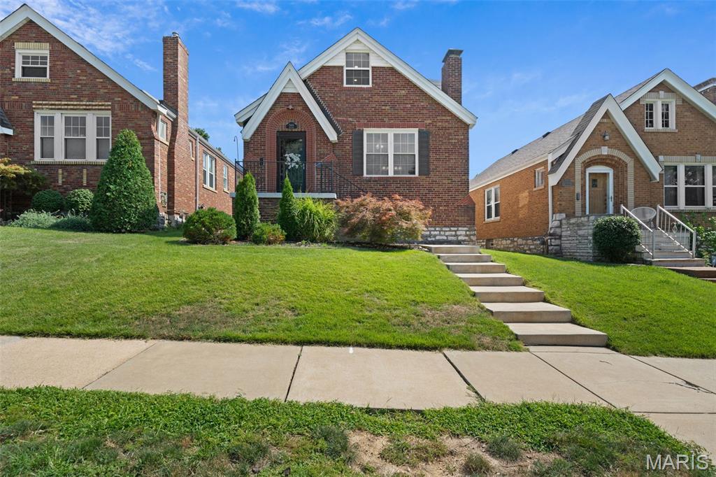 Ooh la la... 5444 Tholozan has that certain je ne sais quoi. This South Hampton sweetheart proves first impressions really do matter. From the striking brick exterior to the crisp black trim, this gingerbread beauty is impossible to miss. Step inside to beautiful hardwood floors, an original stained glass front door + timeless details that make these classic homes *so* special. The cozy living room is filled with natural light from oversized double hung windows before flowing into the dining room + beautifully updated kitchen complete with custom dark wood cabinetry, granite countertops, stainless steel appliances, mosaic tile backsplash + bar seating; holding everything from your morning coffee to charcuterie boards on girls' night... or, let's be honest, the day's Amazon packages. Voila! Just beyond the kitchen is a stunning four seasons room wrapped in exposed brick, making the ideal home office, reading nook or second living space. But the true showstopper? A main floor primary suite that feels straight out of a boutique hotel. Hardwood floors, a decorative fireplace flanked by charming windows + a dreamy ensuite featuring a walk-in shower, granite vanity + custom walk-in closet make this a rare South City find. A beautifully updated powder room + laundry room with built-in storage round out the main floor. Upstairs you'll find two spacious bedrooms with hardwood floors, fresh carpet + closets so large they could practically double as dressing rooms. The updated hall bath keeps mornings simple while the partially finished basement offers plenty of room for storage, hobbies or future finishing touches. Out back, you'll quickly be saying bon appetit to summer dinners on the deck overlooking a quaint backyard and privacy fencing. Say au revoir to replacing flimsy patio furniture every few years because the built in seating has you covered. And the updates don't stop there with new concrete front steps (2022), a new roof, gutters and furnace (2025), fresh chimney tuckpointing + waterproofing (2026), plus a freshly re-stained deck (2026). A one car garage makes the perfect workshop or extra storage space. Just minutes from neighborhood favorites like The Mack, La Catrina, Menya Rui, Los Arcos, The Royale, Uncle Bill's, Tilles Park and so much more, this Southampton sweetheart is ready for its next chapter. A bientot... if you're quick. CHEERS!
