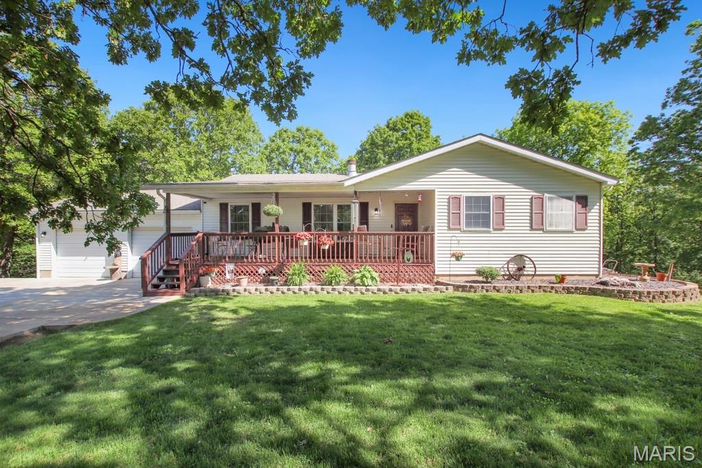 Escape to your own country oasis just 5 miles from town! This beautifully maintained ranch-style home sits on 13.28 scenic acres, offering the perfect blend of peaceful rural living and everyday convenience. Designed with space and comfort in mind, the home features 4 bedrooms and 4 bathrooms, 2 non conforming bedrooms, an office, also including two main-level master suites. The finished walkout lower level provides even more flexibility with two additional bonus sleeping rooms, a spacious living and recreation area, and a large laundry and storage space, ideal for guests, hobbies, or multi-generational living. Enjoy breathtaking views from both the covered front porch and covered back deck. Inside, you’ll appreciate custom cabinetry, a separate dining room, and a stunning fireplace that anchors the main living area. The finished basement adds valuable living space while maintaining warmth and functionality throughout the home.  The property truly shines outdoors with a large 5-bay shop complete with lean-to, wood stove, heated workspace, office with AC unit, half bath, and a dedicated man cave area with kitchenette, a dream setup for welders, hobbyists, or business owners alike. The land offers a beautiful mix of pasture and wooded acreage, perfect for a mini farm lifestyle. The property is fenced for horses, includes a chicken coop, and even features a peaceful glass greenhouse, ideal for gardening, relaxing, or creating your own private retreat. This exceptional property offers space, versatility, and country charm all in one incredible setting. Schedule your private showing today and experience everything this home has to offer!