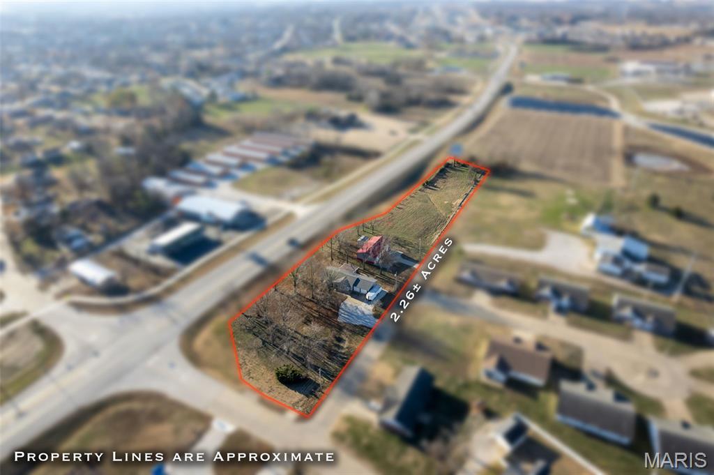 Discover a unique opportunity to enjoy comfortable living while building equity in a commercially zoned area. This 2.26-acre property offers a 3-bedroom, 2.5-bath home with plenty of usable space inside and out. The open kitchen and dining area create an inviting layout, while the main-level laundry and spacious primary suite add everyday convenience. A bright sunroom—heated and cooled for year-round enjoyment—adds even more flexible living space. Major improvements were completed in 2021, including the roof, vinyl siding, and most windows. The full basement expands your options with a kitchenette, bathroom, and a walk-up to the backyard, making it ideal for guests, hobbies, or additional living space. Outdoor living is easy with a covered deck that leads down to a beautifully stained concrete patio overlooking the backyard. A 30x56 insulated metal outbuilding, built in 2018, offers incredible versatility with concrete floors, an insulated door, bathroom, permanent auto lift, air compressor with air lines, and its own heating and cooling. Whether you're looking for room to spread out, space for projects, or an opportunity to live and invest in an area with future potential, this property delivers a rare combination of comfort, utility, and value. Interior photos coming in January. Duplicate listing #25080813