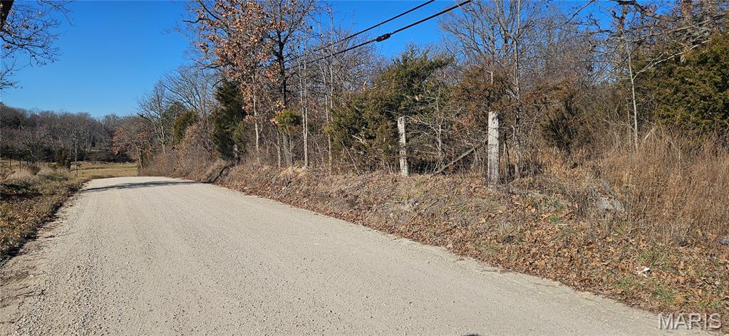 9.4 acres m/l of wooded land located just outside of the city limits.  Great road frontage. Marketable timber.  No restrictions. County water and electric available at road.  Pond. Build your forever home or build a new subdivision for many forever homes!  Your choice!