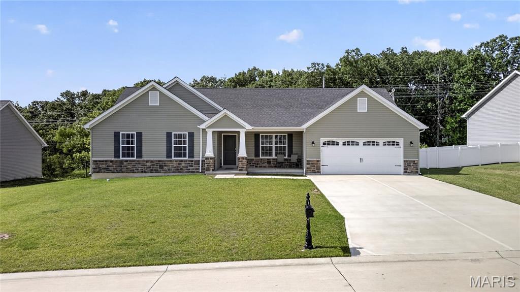 Welcome home to this attractive 3-bedroom, 2.5-bath ranch situated on a quiet cul-de-sac in a desirable neighborhood. A charming covered front porch welcomes you into this well-maintained home featuring low-maintenance vinyl and stone exterior and a 2 car entry with 3-car tandem garage. Step inside to a spacious living room highlighted by plush carpeting and a cozy electric fireplace, creating the perfect gathering space. The open kitchen offers a large center island, beautiful wood cabinetry, black appliances, a walk-in pantry, and plenty of workspace for cooking and entertaining. Durable wood-look vinyl flooring flows throughout the kitchen, laundry room, and hallways. The spacious primary suite features a large walk-in closet and a private bath complete with double sinks, a walk-in shower, linen closet, and easy-care vinyl flooring. Two additional bedrooms and a convenient main-floor laundry room provide comfortable everyday living; The walkout lower level offers endless possibilities for future finishing and includes a rough-in for a half bath. Step outside to enjoy the huge backyard enclosed by a white vinyl privacy fence, perfect for entertaining, pets, play, or relaxing outdoors . With its functional floor plan, generous living spaces, and room to grow, this home is ready for its next owner to enjoy!