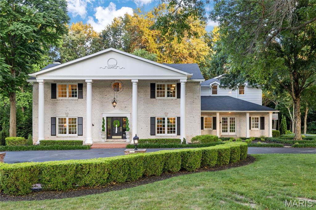 Located in one of Ladue’s premier gated neighborhoods, this spectacular 2-sty Estate home blends the timeless tradition of classic architecture with carefully curated details for a refined living experience. The center hall floor plan features well-proportioned rooms with oak hardwoods, custom trim work accents& expansive windows that offer continuous views of the home’s parklike grounds. The grand 2-sty foyer with black & white marble flooring and a dramatic curved staircase opens to formal living & dining rooms enhanced by exquisite millwork and a welcoming family room with a marble fireplace flanked by built-in bookcases and full-height windows that provide an abundance of natural light. Designer kitchen with 42” buff cabinetry, quartz countertops, Wolf, Sub Zero & La Cornue appliances & 8’ center island transitions to the light-filled breakfast room with glass enclosed entrance with skylights & sliding glass door that opens to a gated patio. Front & rear staircases access the vaulted primary bedroom suite with 2 customized walk-in closets & marble bath with soaking tub & steam shower. 3 Additional bedrooms, 2 with ensuite baths, & hall full bath complete the 2nd floor living quarters. Private entrance with French doors leads to a well-appointed office & coffered bonus room with wet bar. Lower Level entertainment space includes recreation room, game room, wine cellar with 1600-bottle capacity & full bath. Situated on a 3.6-acre cul-de-sac lot adjacent to a 50-acre equestrian property with patio, gazebo & resort style pool surrounded by landscaped gardens.