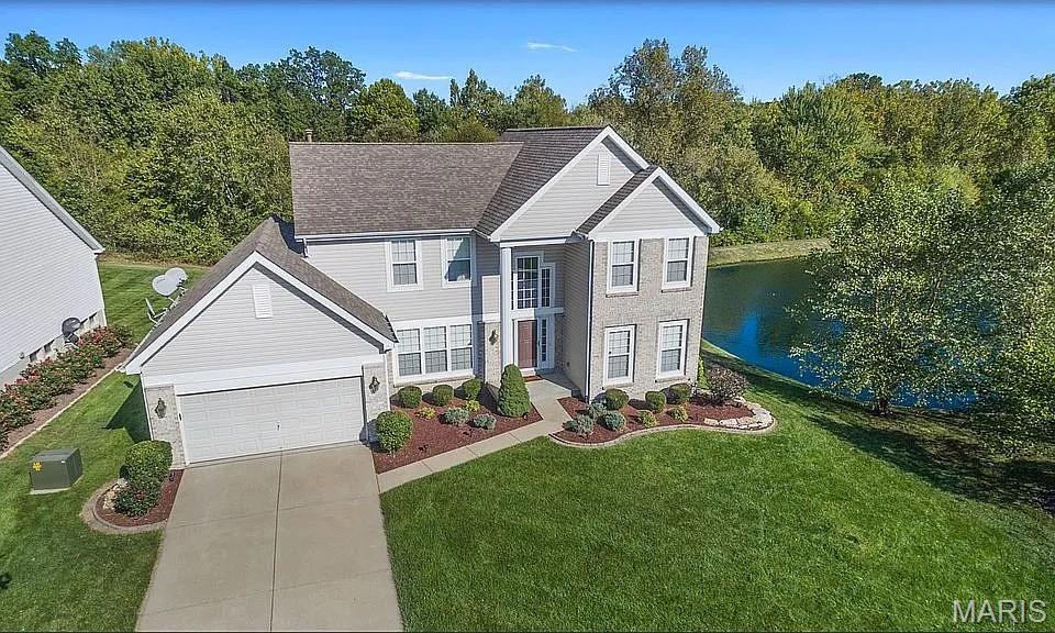 Beautifully maintained two-story home situated on a premium lot with breathtaking views of the retention pond and tree-lined backyard. Filled with natural light, this home features an inviting open floor plan and an impressive T-staircase that creates a grand first impression. Rich wood flooring throughout the main level adds warmth and elegance. At the heart of the home is the expansive family room, featuring an abundance of windows that flood the space with natural light and showcase the picturesque backyard views. A beautiful gas fireplace serves as the focal point, creating a warm and inviting atmosphere for everyday living and entertaining. The spacious kitchen is a chef’s delight, offering 42" cherry cabinetry, granite countertops, and ample prep space. The kitchen flows seamlessly into the breakfast room and family room, making it ideal for gatherings large and small. Step outside onto the composite deck and enjoy the peaceful setting overlooking the retention pond and mature trees.Retreat to the luxurious primary suite featuring a gorgeous newly remodeled spa-like bathroom complete with dual tall vanities, a seamless glass shower, and a soaking tub—the perfect place to unwind at the end of the day.
The fully finished lower level provides exceptional additional living space with a theater area, wet bar, spacious recreation room, dedicated workout area, full bathroom, and plenty of storage. Whether hosting guests, enjoying movie nights, or creating the ultimate game-day setup, this lower level offers endless possibilities. Additional upgrades include a NEW ROOF (2025), NEW BLINDS, custom closet organizers, wired for bidets in the bathrooms, an EV charging station in the garage, and a sprinkler system for easy lawn maintenance. Neighbordhood pool! For added peace of mind, the seller is also offering a Choice Home Warranty. Combining comfort, style, and an unbeatable setting, this remarkable home offers luxury, functionality, and stunning views in one of O’Fallon’s most desirable locations.


--