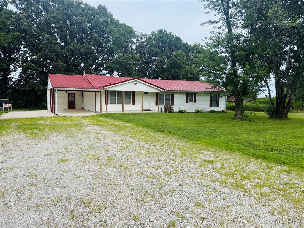 Cute 3-bedroom, 2-bath house on 1.39 acres +/-. Walk in the front door to a nice-sized living room with a semi-open floor plan to the kitchen. The kitchen has stainless steel appliances and beautiful butcher block countertops, giving that perfect country feel. The kitchen island provides additional counter space for prepping and cooking meals. There is a bar-height cedar counter looking into the living room, allowing you to sit for a nice meal or visit with company while cooking. The kitchen has a door leading outside onto a covered carport with an additional concrete pad big enough to park another vehicle, camper, or boat. There is a 30amp plug for an RV just off the pad. Down the hall, you will find the main bath, laundry room, and the 3 bedrooms. The master suite includes a bathroom and a door leading outside to a nice deck. It has a very nice flat yard with a chicken coop area and a small shed.