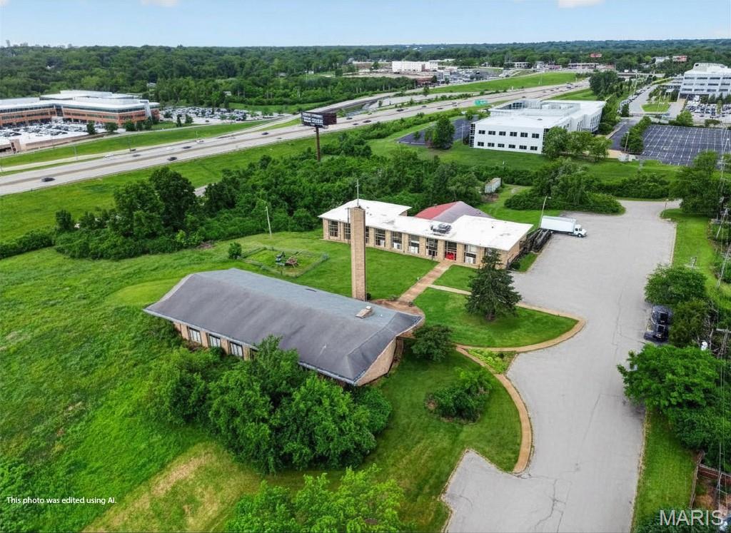 Positioned on 10.74± acres of high-visibility ground in the heart of inner-ring North St. Louis County, 206 Emerling Drive offers one of the most flexible and substantial redevelopment opportunities available in the metro area today. The property is improved with approximately ~45,612 square feet of existing buildings, historically operated as a church-and-school campus, and includes a large worship sanctuary, a connected school wing with classroom spaces, support and administrative areas, an indoor basketball court, and an outdoor ball field — all surrounded by mature, park-like grounds that give the campus a distinctive sense of openness rarely found this close to the urban core.
The site sits within the City of Cool Valley in unincorporated proximity to Normandy, Bel-Ridge, and the University of Missouri–St. Louis, placing it at the convergence of established residential neighborhoods, institutional anchors, and major commercial corridors. Frontage and sight lines from Interstate 70 deliver an estimated 158,302 vehicles per day in exposure, a traffic count that turns the parcel into a true marquee location for any user who values brand visibility or community recognition. The North Hanley MetroLink station is less than a mile away, St. Louis Lambert International Airport is roughly four miles north, and direct access to I-70, I-170, and I-270 puts the entire metro within a 20-minute drive.
Although the property is currently zoned A – Single-Family Dwelling District under Cool Valley’s single-family residential designation, its scale, configuration, and surrounding land uses make it a strong candidate for rezoning to multi-family residential or light industrial — uses that have been actively explored for the site. With 130 existing surface parking spaces, large open-span interior areas, and significant developable acreage, the property is equally well-suited for continued use as a church, school, daycare, charter academy, athletic facility, community center, senior living campus, medical/behavioral health facility, or ground-up redevelopment. Properties of this size and visibility, with this much existing infrastructure already in place, simply do not come to market often in St. Louis County.
