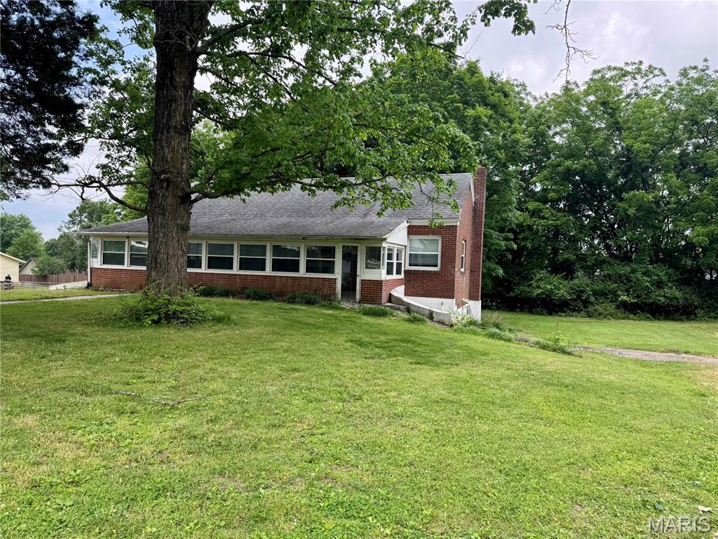 Charming all brick cottage sitting on .44 acres with a private drive in Alma Schrader Elementary district. Large living room with wood floors. Updated bathroom will all tile shower. Features 10 by 36 sunporch and newer windows on the main. Could have 2 main floor bedrooms, but would have to walk through one to get to the other. The large finished area in the basement is a legal bedroom or could be a second living area.