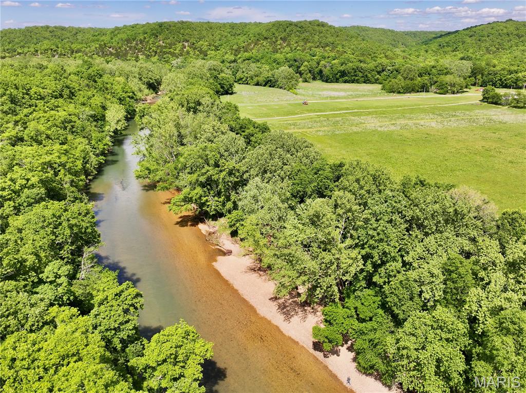 Discover a rare opportunity to own 7.75 surveyed acres on one of Missouri's premier trout streams. Located just 3.5 miles downstream from Bennett Spring State Park, this exceptional Niangua River property features over 600 feet of private river frontage along a highly desirable stretch known for outstanding trout, smallmouth bass, and goggle-eye fishing.

The property offers an ideal mix of open ground and mature timber, with large shade trees lining the riverbank and wooded borders on three sides that create outstanding privacy and seclusion. A driveway is already in place leading to a beautiful build site with buildable acreage outside the floodplain, providing an excellent location for a future home, cabin, or recreational retreat overlooking the river valley.

In addition to the direct frontage, the property includes a secondary complimentary river access point just downstream with access to a large gravel bar, perfect for fishing, swimming, launching kayaks, or simply enjoying a day on the water. Easy access into the river from the property makes it convenient to enjoy everything the Niangua has to offer.

Ready for immediate use, the property comes complete with a 200-amp electric service, camper hookup, camper, deck, and fire pit, allowing you to start enjoying the property the day you close. Border fencing on three sides and a gated entrance provide added security and peace of mind.

Whether you're searching for a weekend getaway, a premier fishing retreat, or a future riverfront homesite, this property checks every box. River tracts this close to Bennett Spring with utilities installed, established improvements, buildable acreage, exceptional privacy, and over 600 feet of direct Niangua River frontage are becoming increasingly difficult to find. Don't miss your chance to own a turnkey river property in the heart of Missouri's trout country.