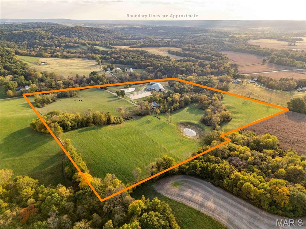 Welcome to your private rural retreat! This versatile 45.8-acre property seamlessly blends upscale country living with exceptional infrastructure. Whether you are seeking a premier hunting sanctuary, an equestrian setup, a working hobby farm, or simply space to store your heavy equipment, this property delivers unmatched functionality and privacy.

Improvements include a custom log house, a detached garage (with additional living quarters), a horse barn with an indoor arena, an outdoor arena with turnouts, and a shed.

The log home is a unique gem, featuring a main-level primary suite with a walk-in custom closet, a soaking tub, and a heated bathroom floor. The main level boasts a gas fireplace, a half bath, a mud room with a heated floor, and a tongue-and-groove ceiling. The kitchen is equipped with an island, a propane range, a dishwasher, and a walk-in pantry. All appliances will be conveyed with the sale. Adjacent to the main level is a large deck with a spectacular view, a fireplace, and a bar, perfect for entertaining!

The walk-out basement offers a cozy retreat with a laundry room and two bedrooms, one of which is a non-conforming space that can serve a variety of purposes. Additionally, it boasts a man cave, complete with a wood stove.

The upper-level open loft overlooks the main living area. It includes a closet and a bathroom with a shower, making it suitable for a guest room or an office.

The detached two-car garage, conveniently situated beside the home, features a three-quarter bathroom on the main level. The upper-level features tongue-and-groove paneling, creating a warm, inviting atmosphere. This space also includes a closet, making it an ideal retreat for visitors.

The property features a beautifully landscaped yard with vibrant plants and greenery. It boasts an array of mature fruit trees, providing a delightful harvest of fruits throughout the seasons, as well as a newly constructed pond and an existing pond.
