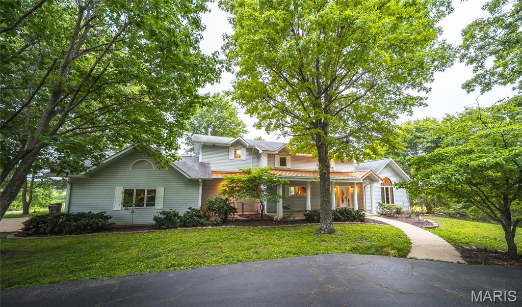 Luxury living on your terms. This exceptional custom home is now available with approximately 5–15 acres (price based on 10 acres), offering buyers the rare opportunity to enjoy all the elegance, privacy, and functionality of the original estate on an acreage that fits their lifestyle. Whether you’re dreaming of room for horses, a hobby farm, or simply a peaceful country retreat, this property delivers high-end finishes, resort-style outdoor living, and breathtaking views in a manageable package. Additional acreage may be available.

The main level impresses with an open floor plan anchored by a striking central floating staircase. The chef’s kitchen features a large center island perfect for gathering, while the expansive living room floods with natural light beneath vaulted ceilings. Thoughtful architectural details carry through every room. Step out from the main level onto the deck and down the stairs to the pool and patio area below — a natural flow for entertaining from inside to out.

The primary suite is a world unto itself — fully reimagined with a dedicated media room, a spa-caliber bathroom with soaking tub, oversized tile shower, and a private deck for a breath of fresh air without ever leaving your retreat. A massive walk-in closet with mirrored built-in shelving and dedicated in-closet laundry keeps life convenient without missing a beat. And for the book lover or the dreamer, a hidden library with floor-to-ceiling custom built-in bookshelves awaits behind a secret door.
The walk-out lower level is just as impressive. Beautifully finished with 9-foot tray ceilings, the basement bedrooms each feature their own walk-in closets — offering guests or family members a retreat that feels anything but basement-level. Step outside directly to the in-ground pool and patio, where the surrounding trees and natural beauty of the property create a setting that’s hard to leave.

A metal outbuilding provides ample storage for equipment, livestock needs, or hobby space. The land is fully fenced and ready for horses or other livestock, with timber and rolling terrain that make every acre a pleasure to explore.

Properties like this don’t come around often — and they don’t last long.
Agent owned and lovingly maintained — now offered due to out-of-state relocation.

This listing is a subdivision of MLS #26029329 and is offered with approximately 10 acres (additional acreage available). Price reflects 10 acres.