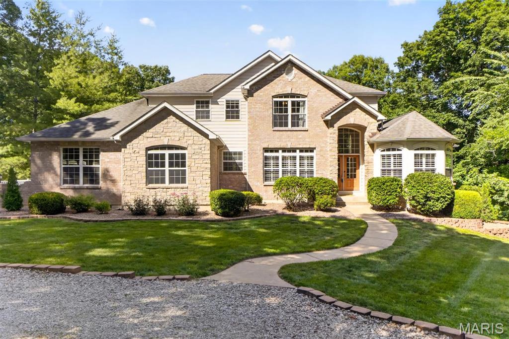 Nestled within the sought-after Springhaven Subdivision, this impressive 5-bedroom home is set on 5 wooded acres, offering a rare combination of neighborhood convenience and peaceful seclusion.
The kitchen features granite countertops, custom cabinetry, a center island, stainless steel appliances, a hearth room with a double-sided fireplace, and a breakfast area positioned to capture scenic views of the property.

The main level welcomes you with wood flooring, tasteful neutral color tones, a formal dining room, and a private study. The dramatic two-story great room is highlighted by built-in shelving and expansive atrium windows that flood the space with natural light. The main-floor primary suite serves as a relaxing retreat with a coffered ceiling, dual vanities, and a spacious walk-in closet. Three additional bedrooms complete the second level.
Designed for both everyday living and entertaining, the finished lower level features a fireplace, elegant wet bar, recreation room, fifth bedroom, and walk-out access to the backyard. 3 car garage and ample parking for guests. 

Outdoor living is enhanced by a newer composite deck and paver stone patio, creating the perfect setting to enjoy the beauty and tranquility of the wooded surroundings. Combining generous living spaces, thoughtful updates, and an exceptional 5-acre setting, this property offers an ideal blend of comfort, sophistication, and space.